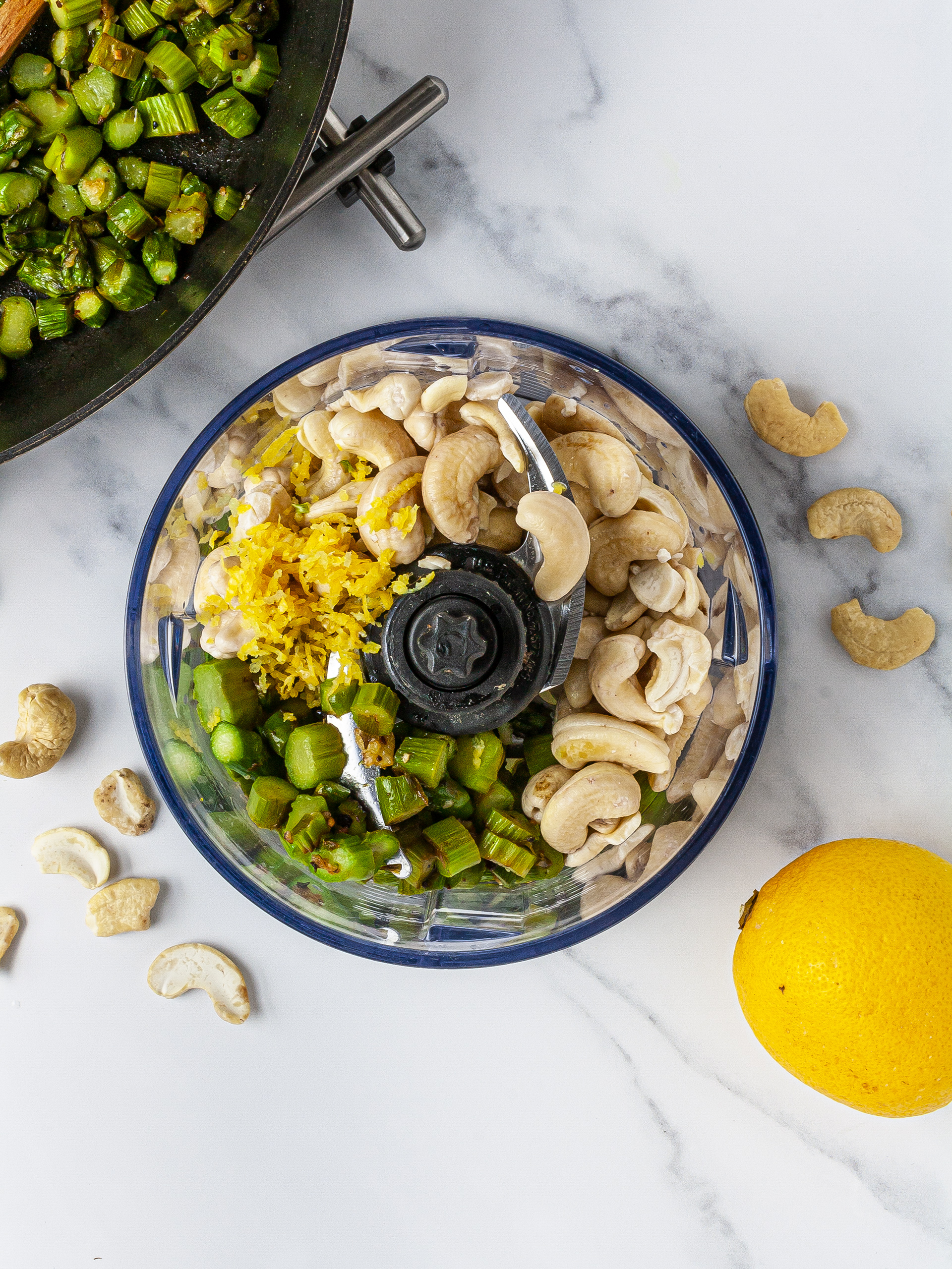 Asparagus, cashew nuts, and lemon zest in food processor. 