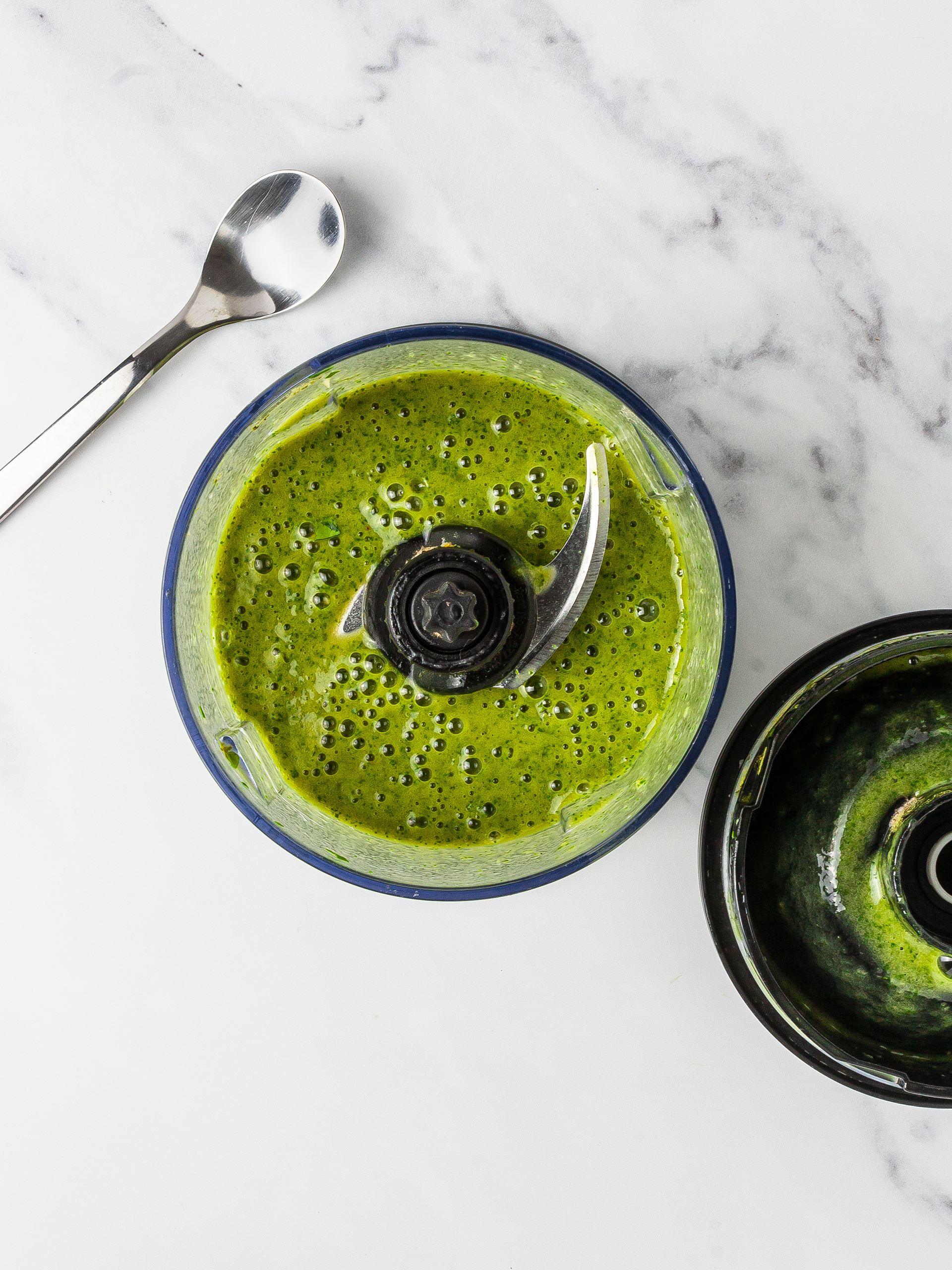 Blended green smoothie in a food processor.