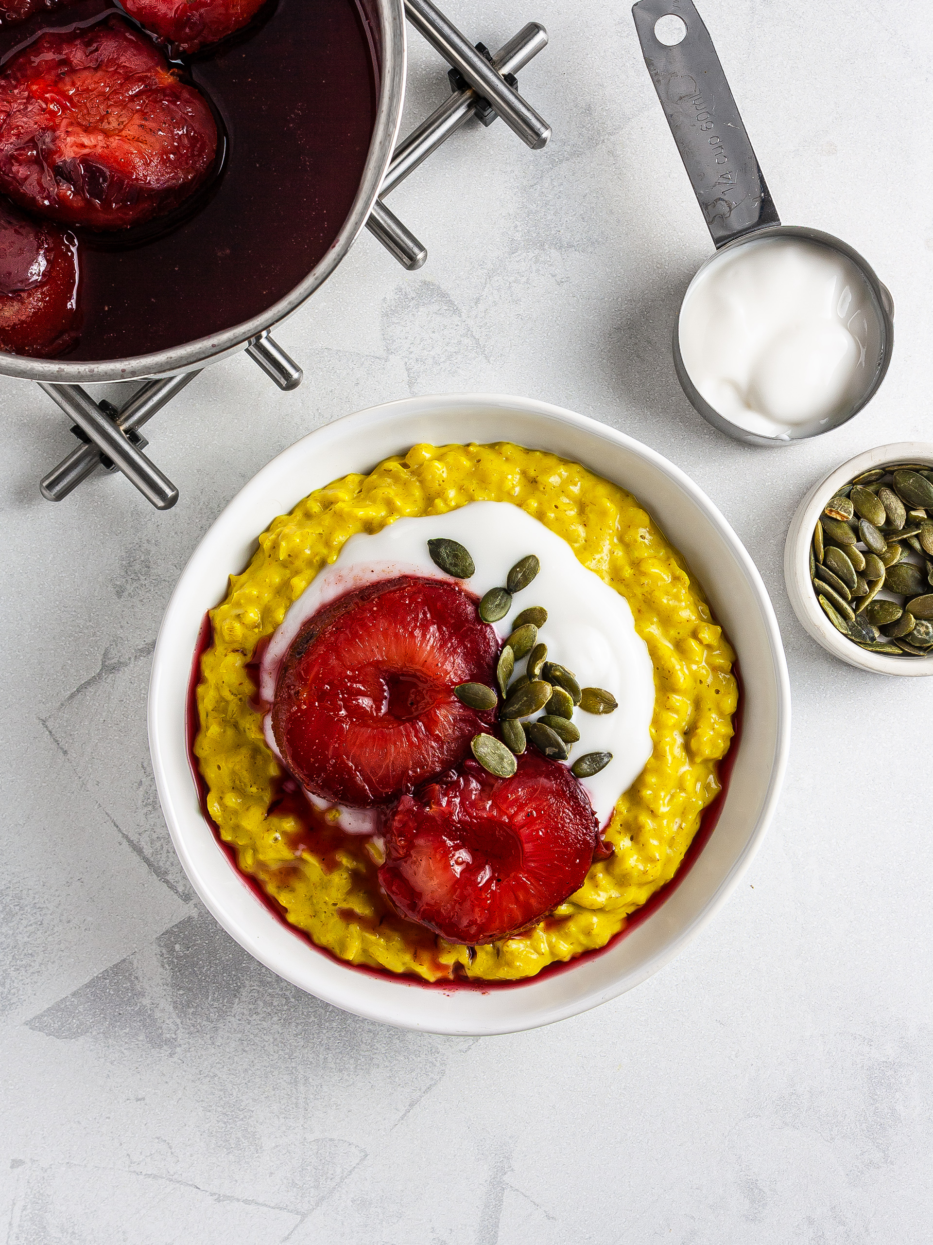 Golden oatmeal topped with yogurt and pumpkin seeds