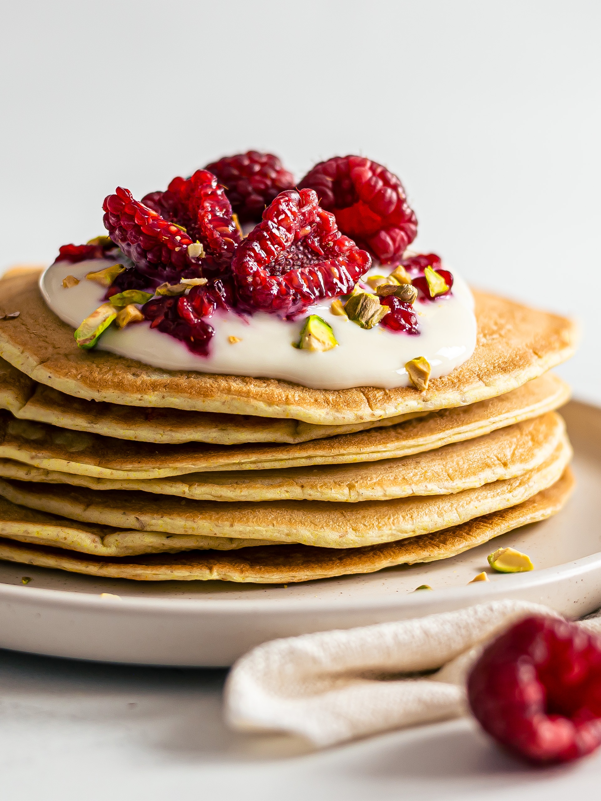stack of vegan sourdough pancakes topped with yogurt and berries