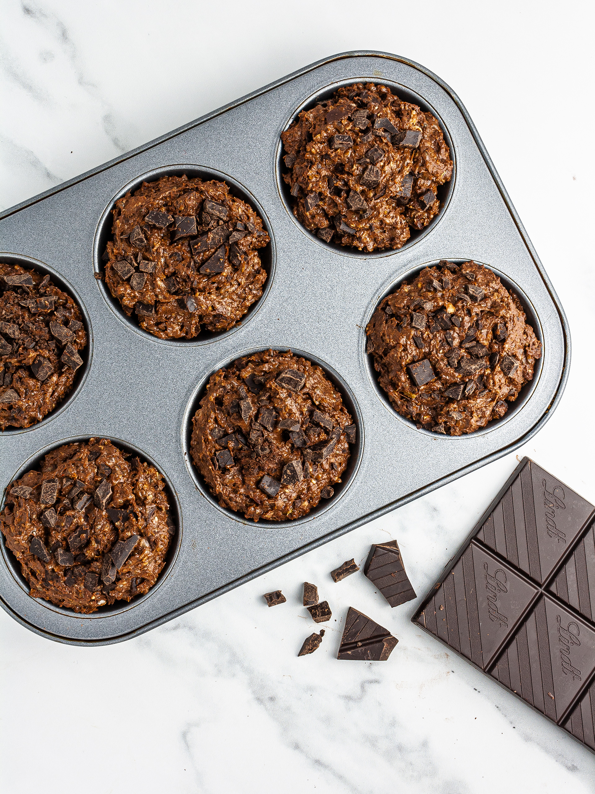 Muffin dough in baking tray with chocolate chips