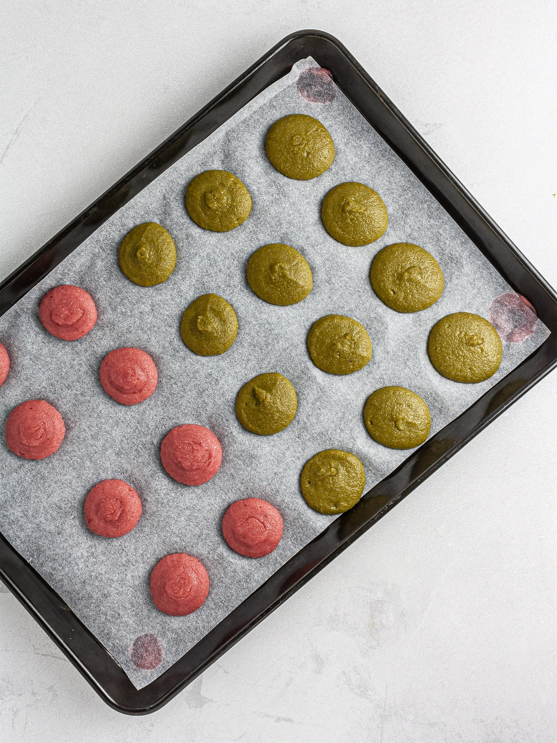 Macaron batter piped over baking tray