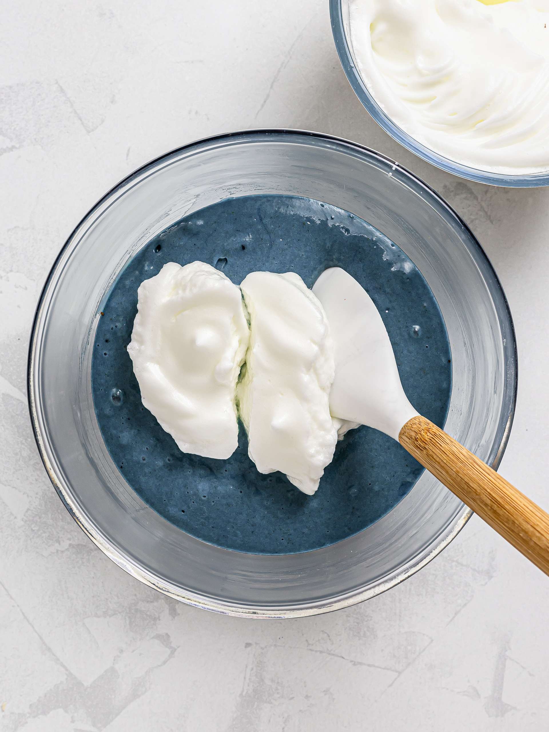 beaten egg whites folded into blue cake batter