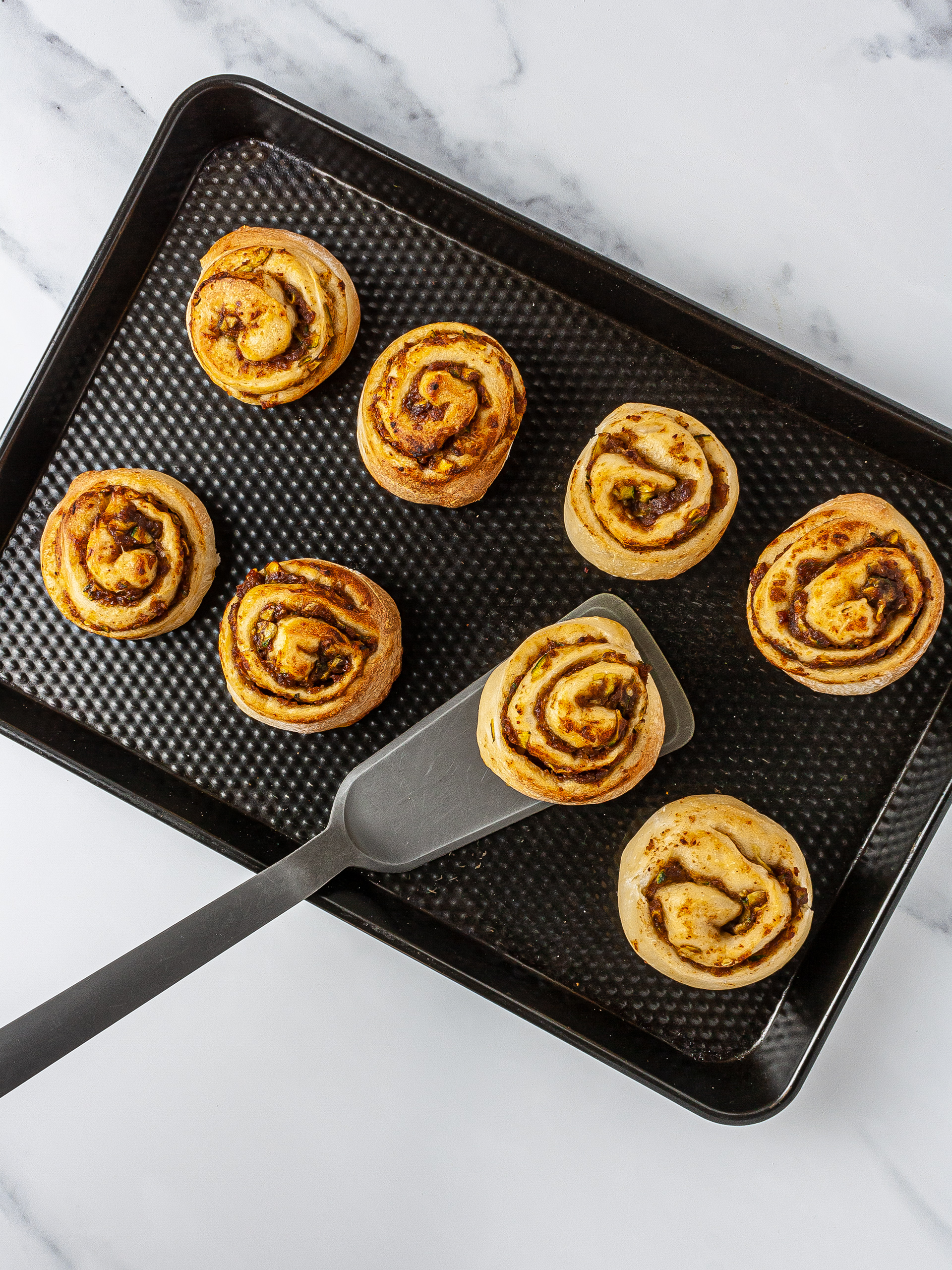 Baked zucchini cinnamon buns on tray.