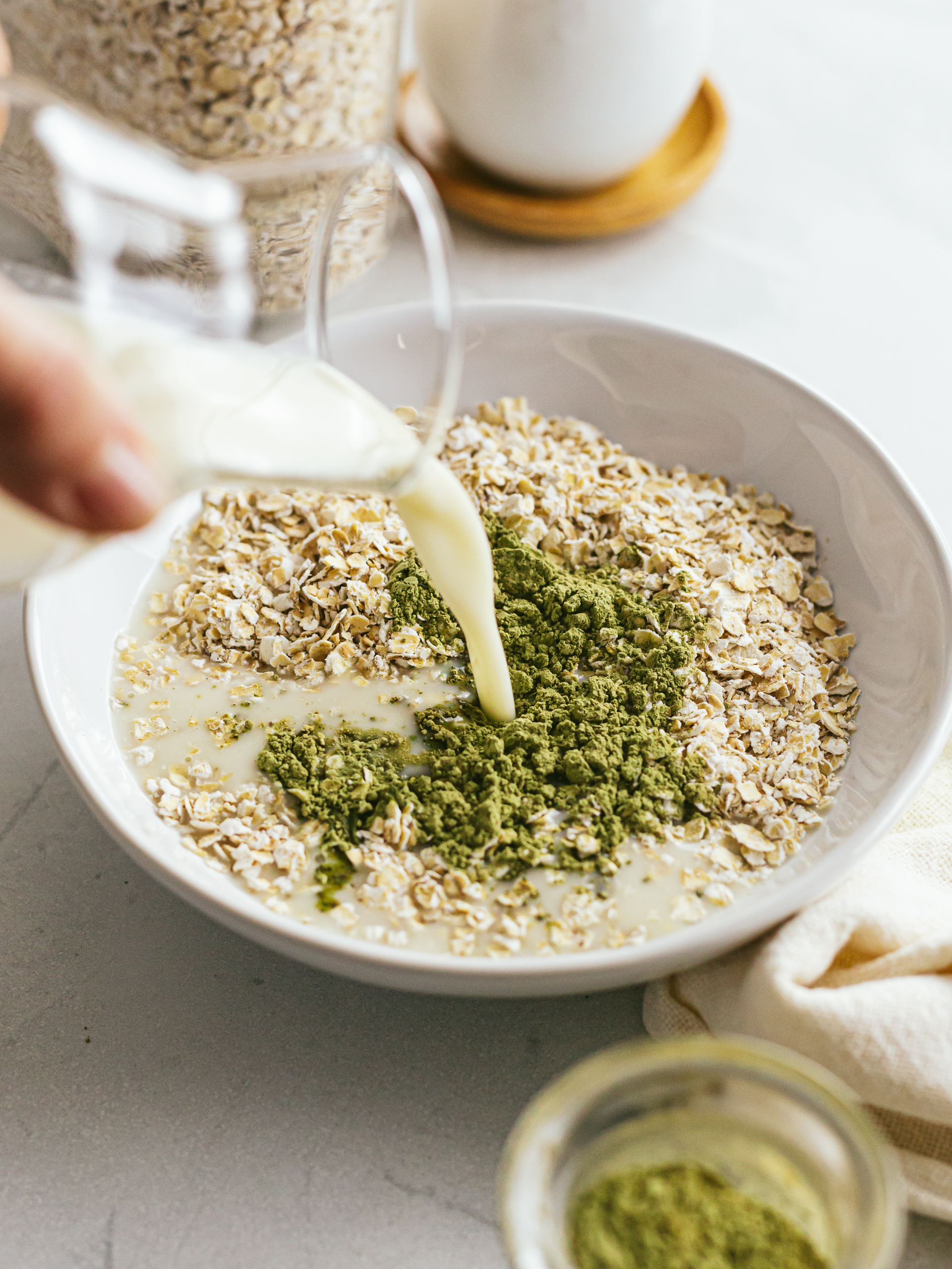 Pour milk into a bowl with oatmeal and matcha powder