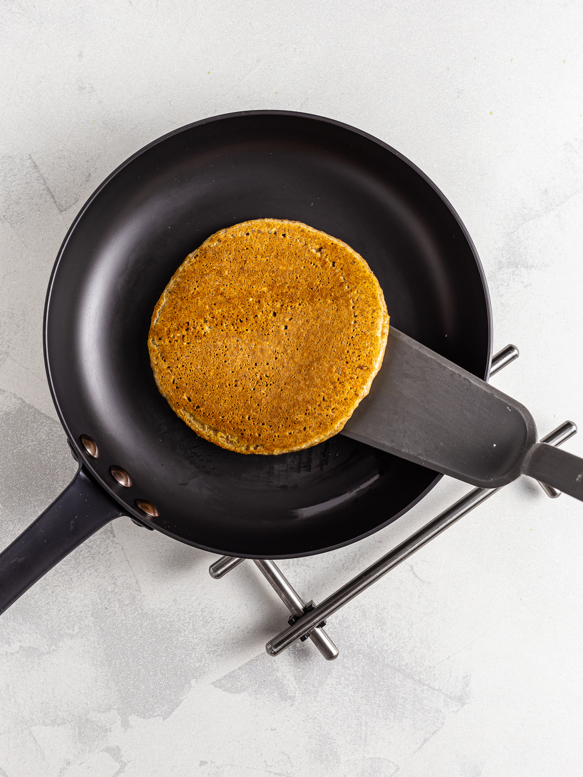 Flipped lentil pancakes in a skillet