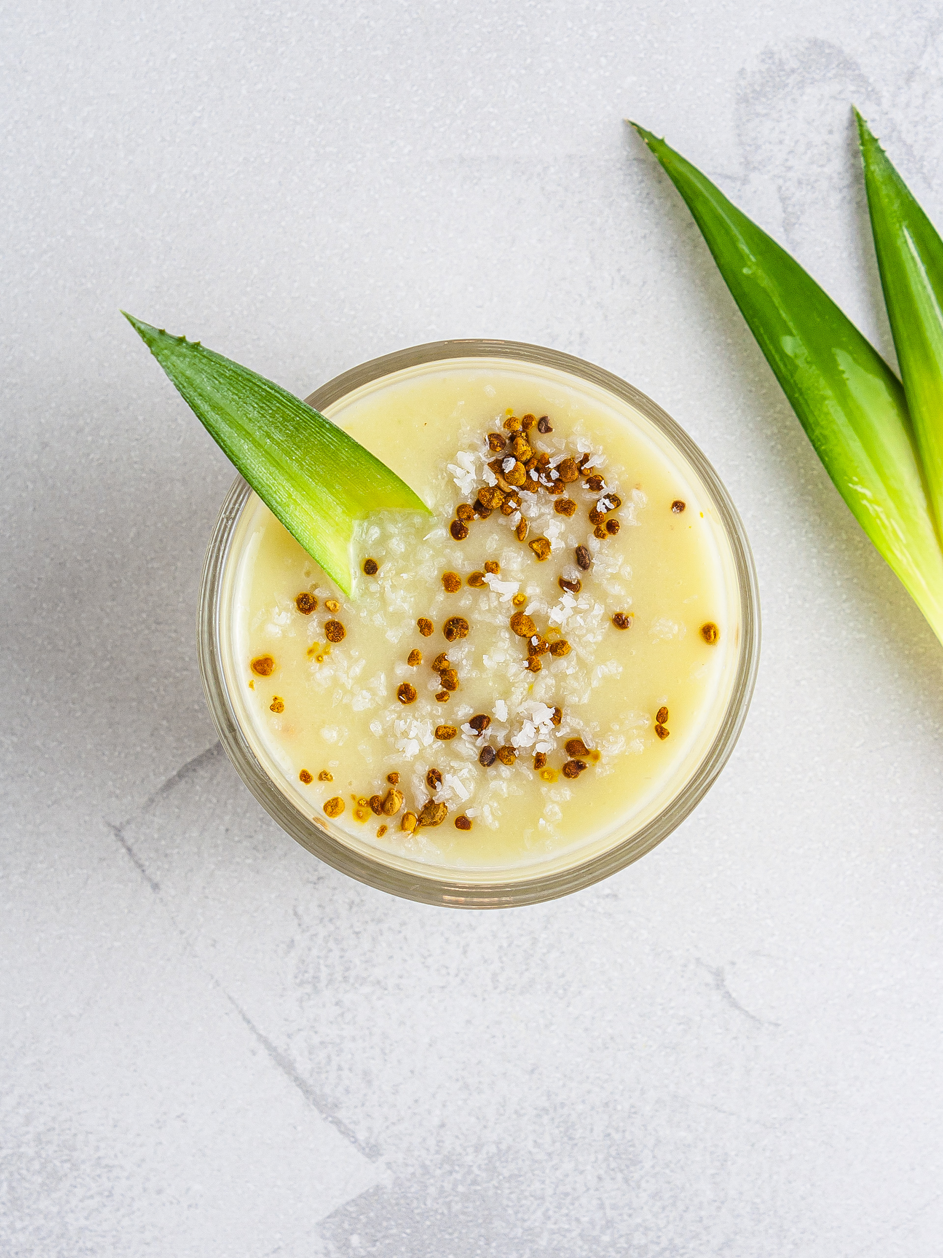 Pineapple guava smoothie in a glass with bee pollen