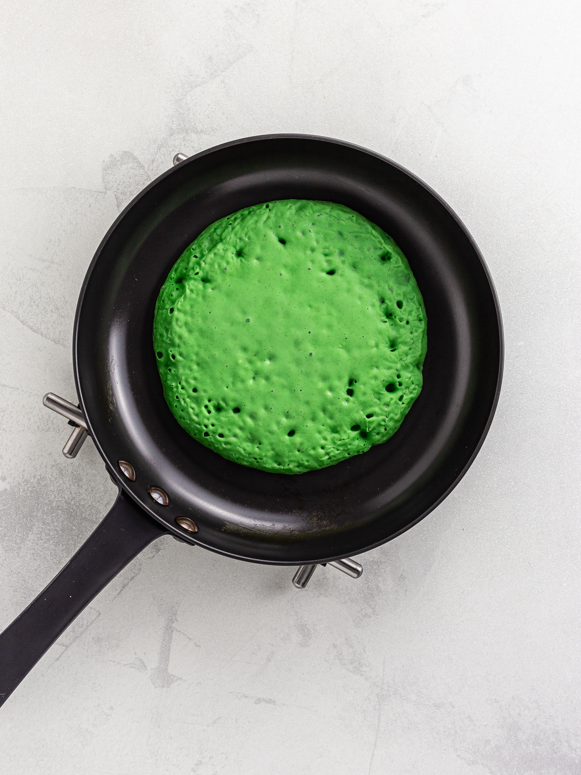 pandan pancake cooking in a skillet