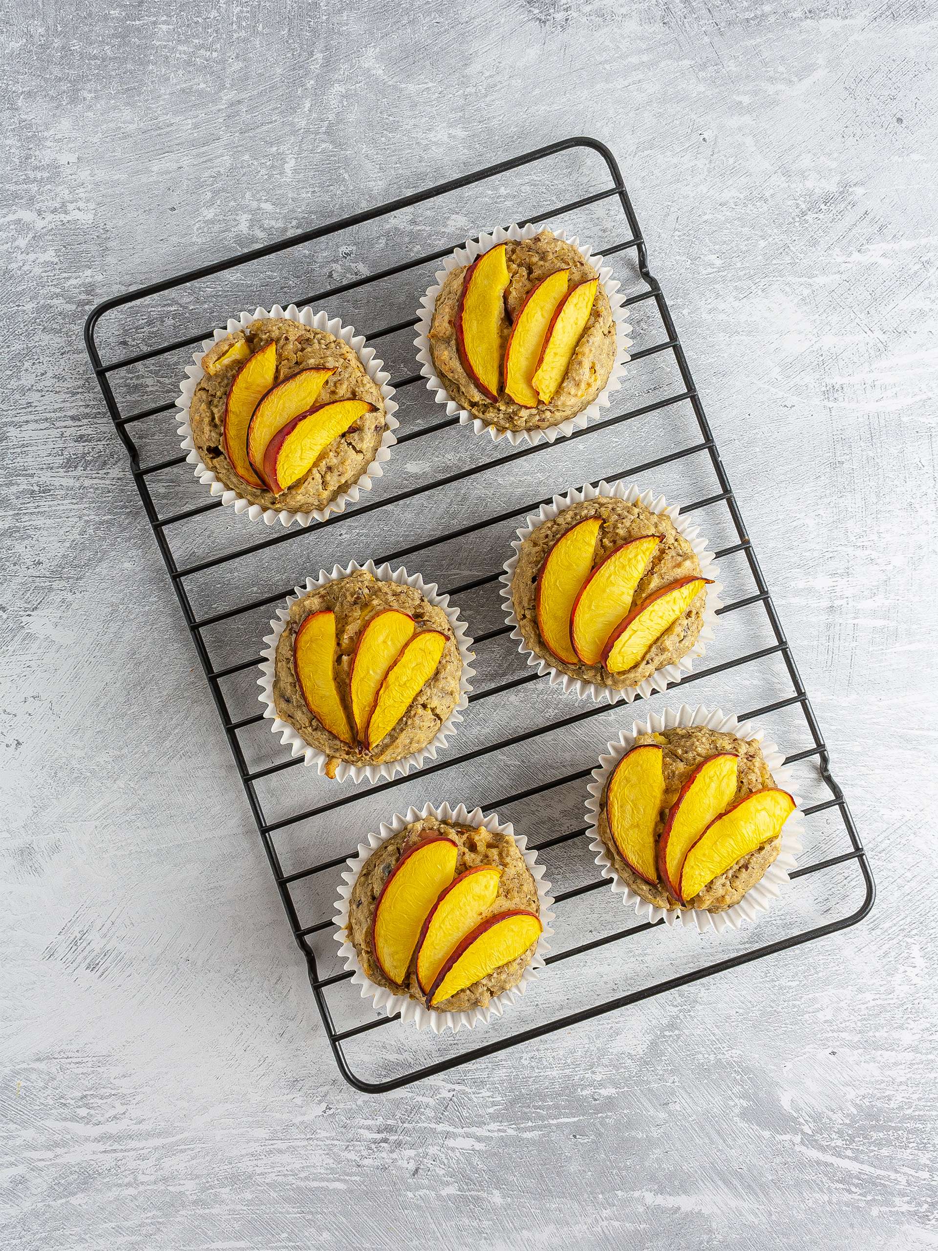 Baked peach muffins on a cooling rack