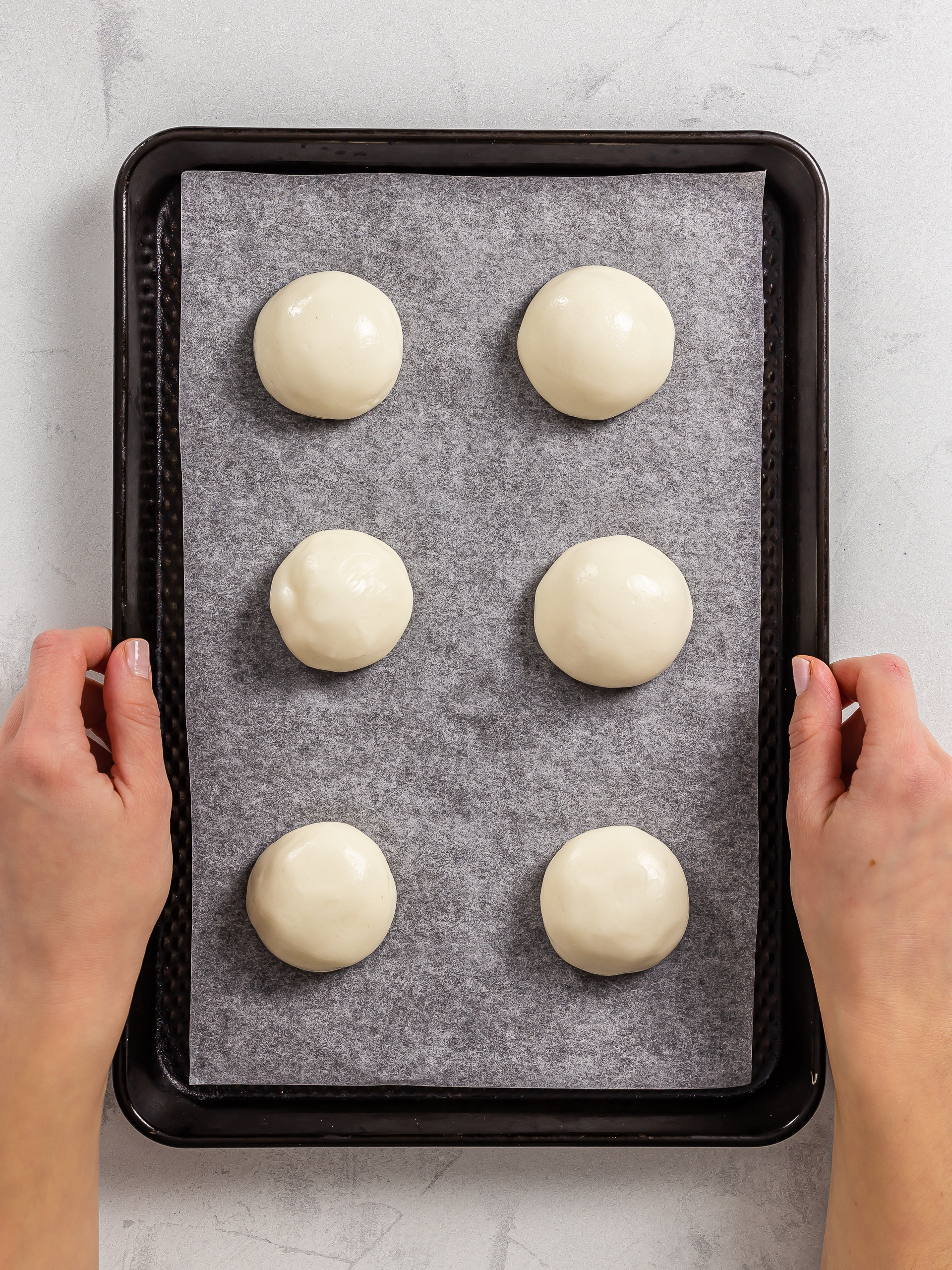 woman showing a tray of mochi cookie balls