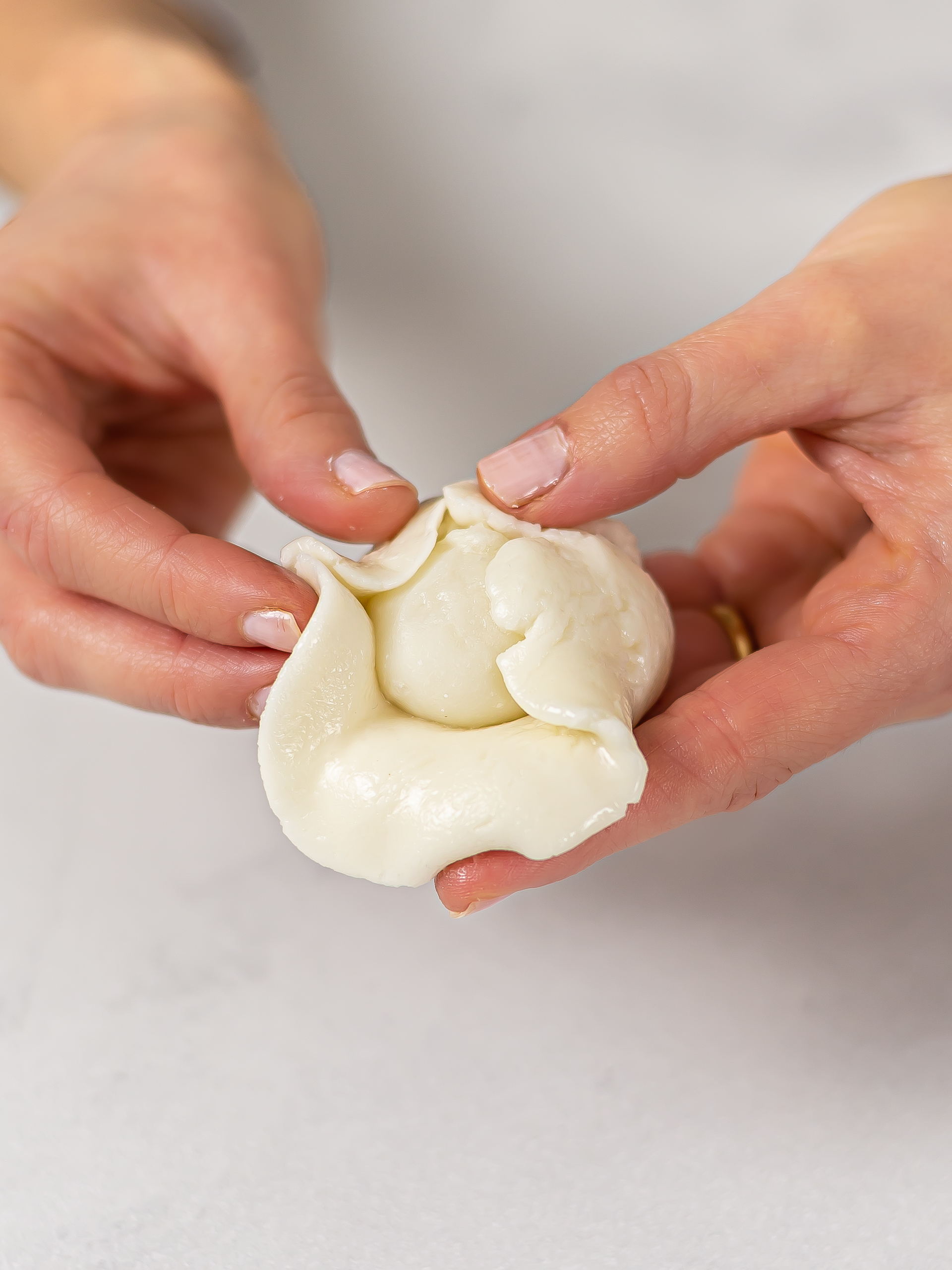 woman wrapping mochi cookie dough around soft mochi filling