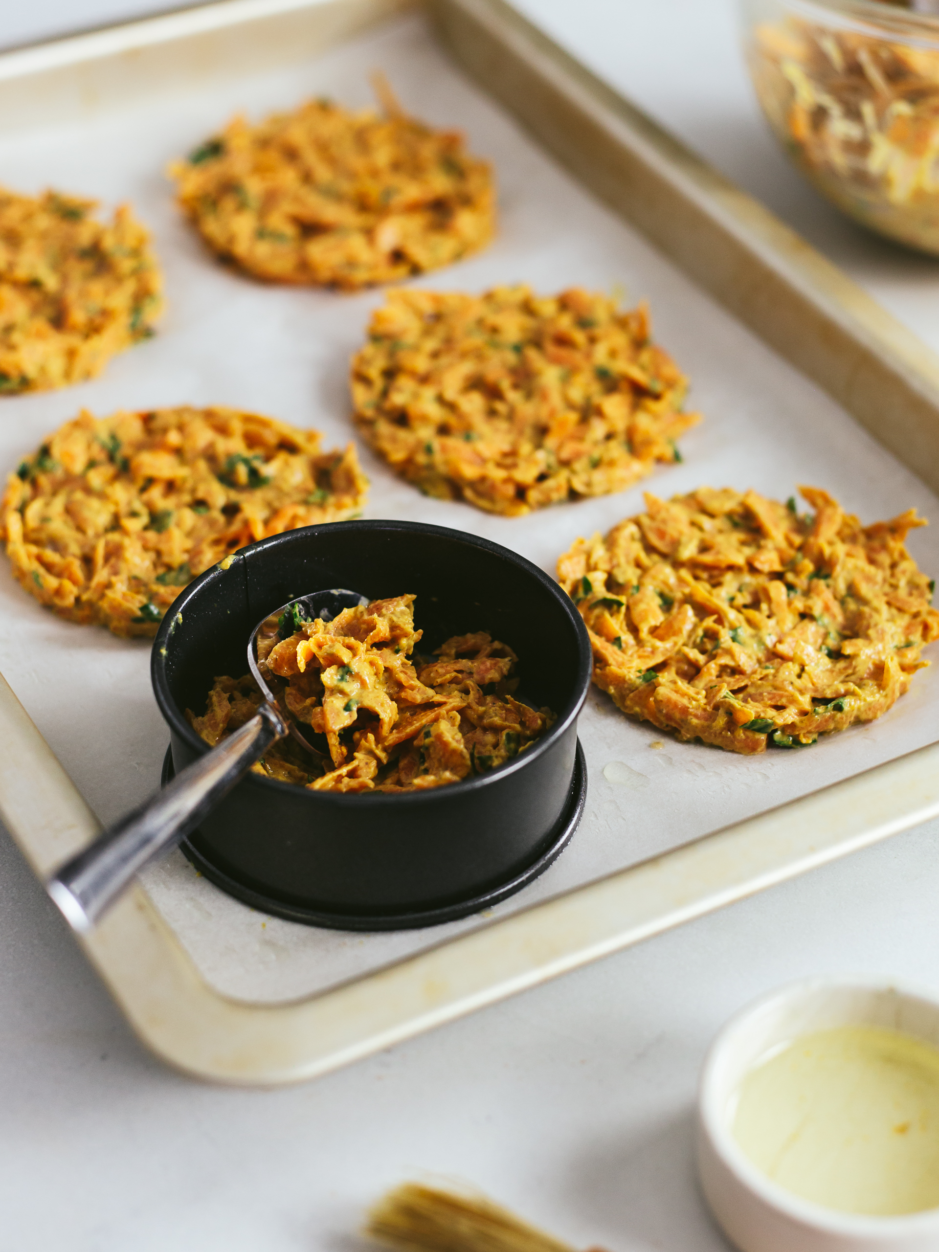 shaped carrot hash brown patties on a tray with a ring
