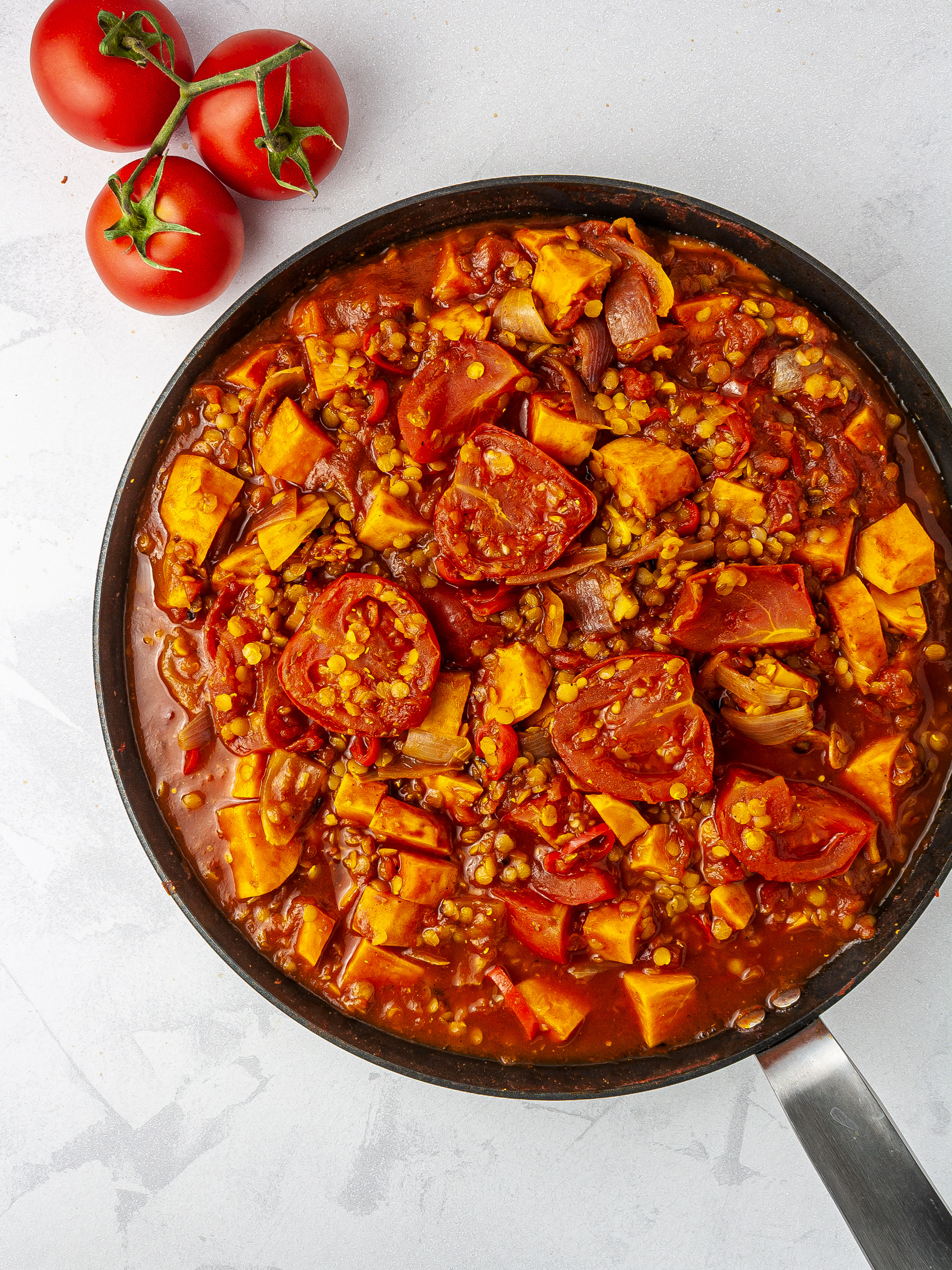 Vindaloo curry with halved tomatoes.