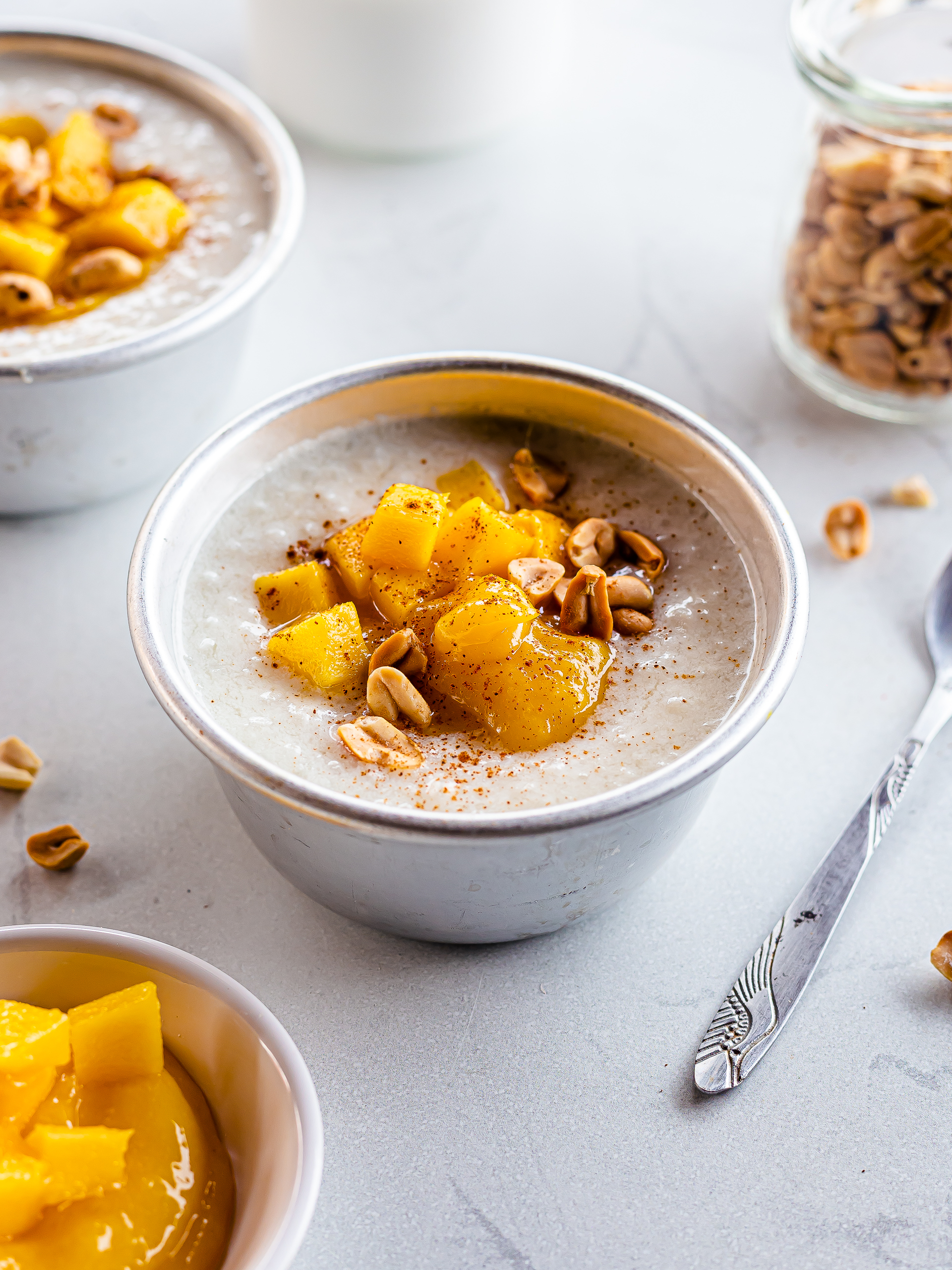 sweet breakfast congee topped with mango cinnamon and peanuts