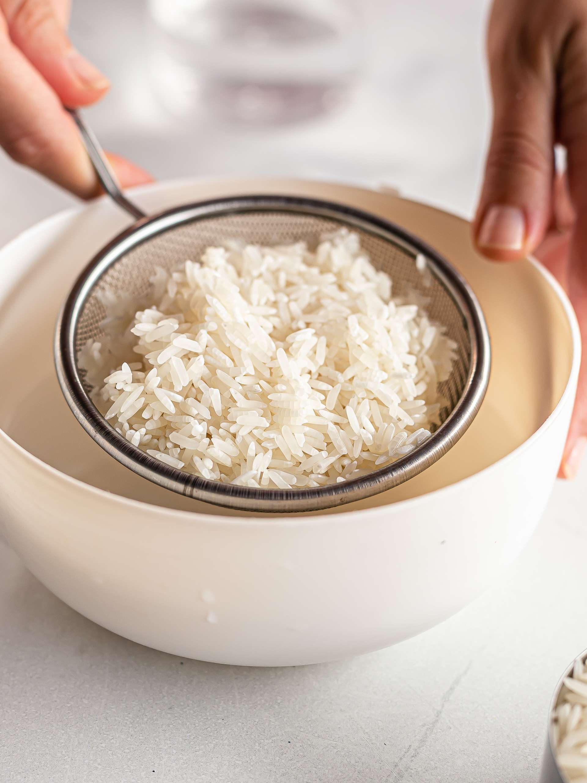 rinsed and drain white long grain rice on a colander