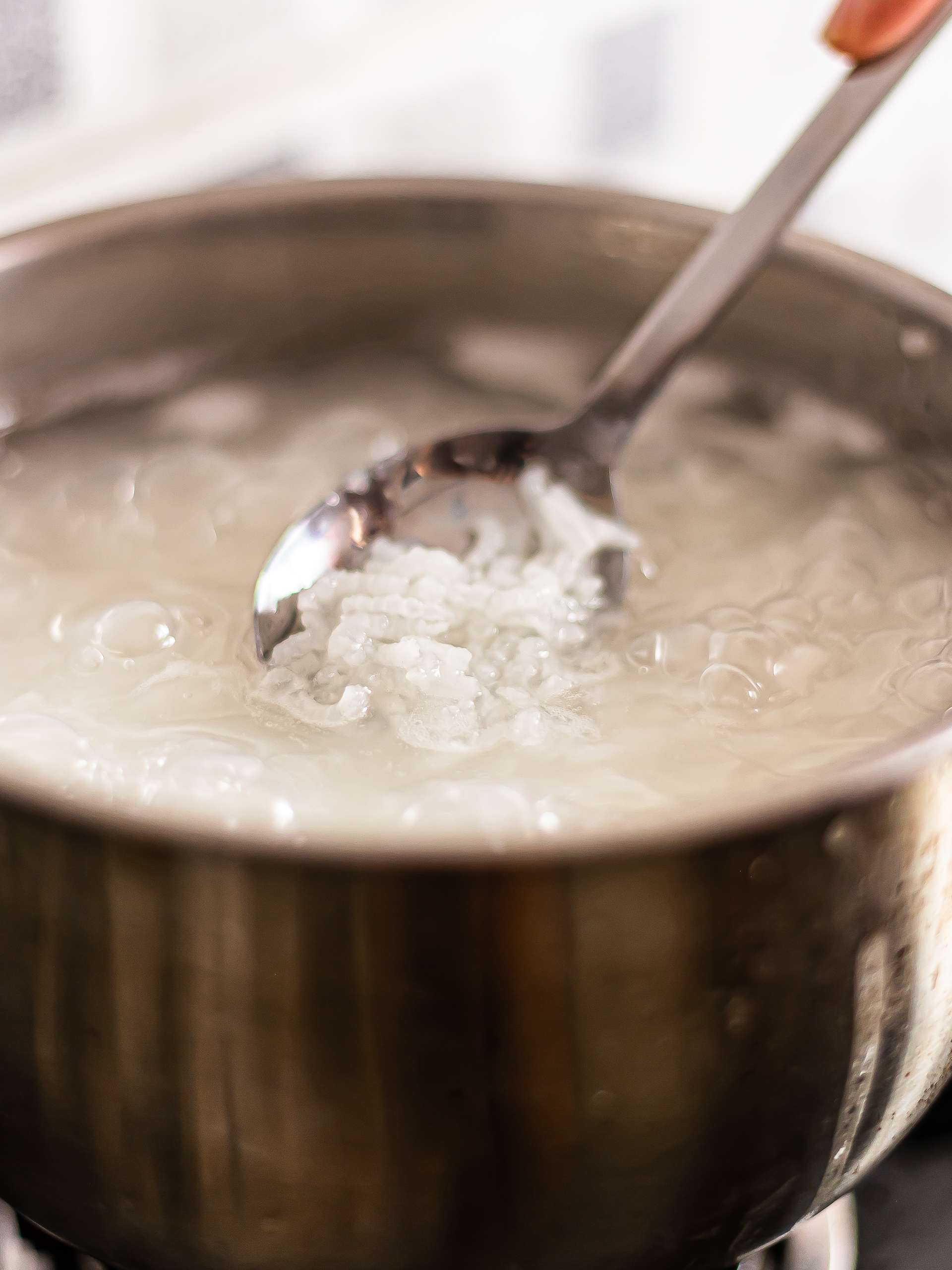 white rice simmering in a pot for congee