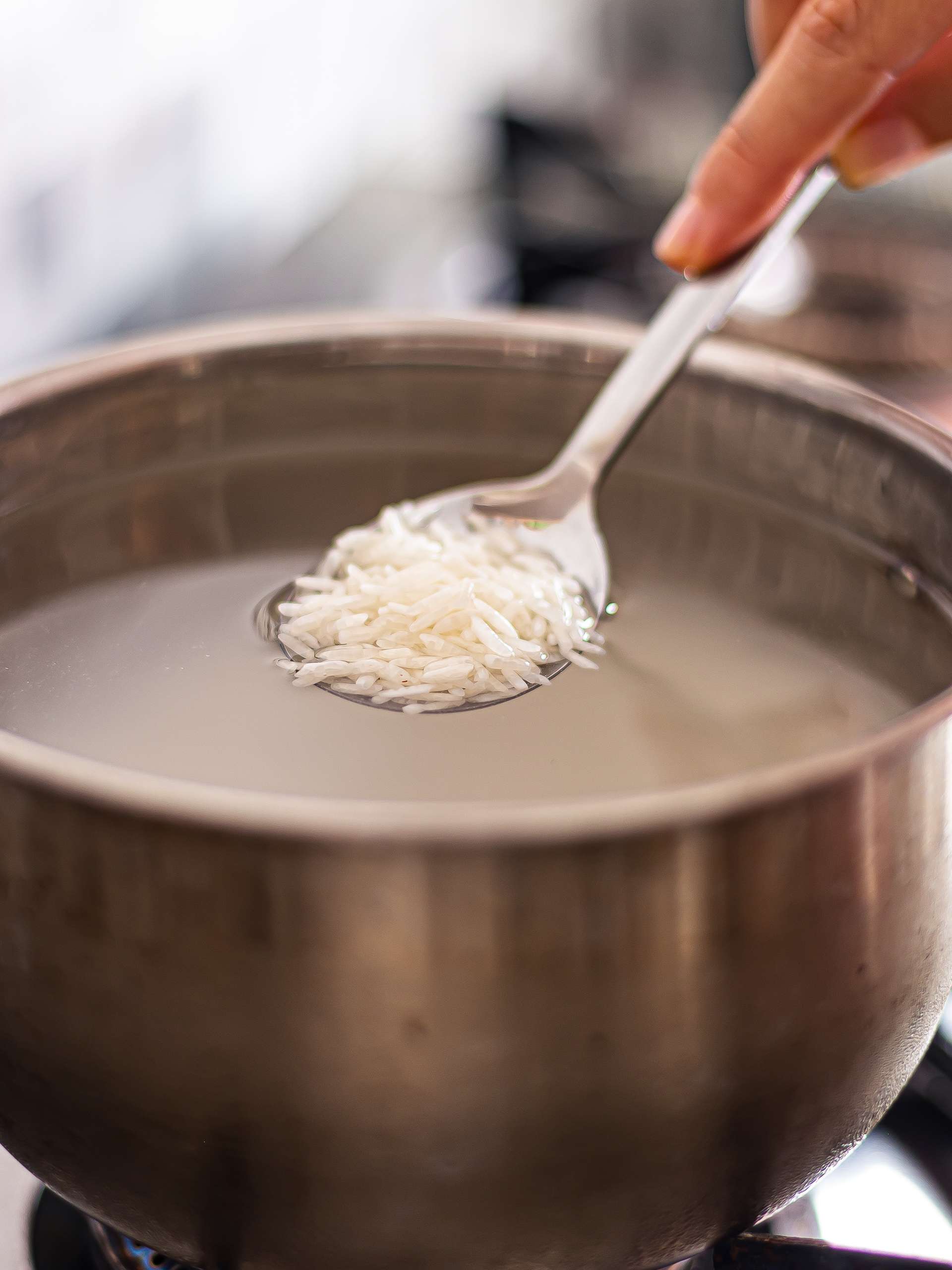 white rice in a pot of water to make rice porridge congee