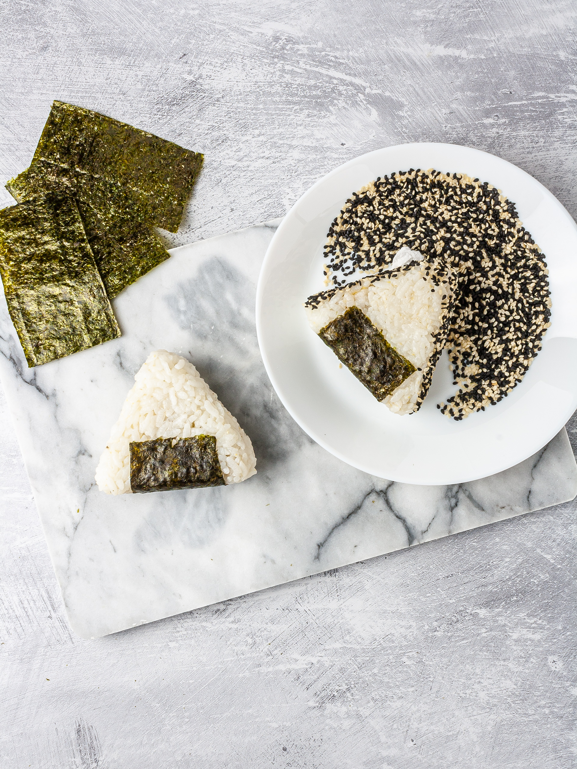 Vegan onigiri wrapped in nori sheet and coated in sesame seeds.