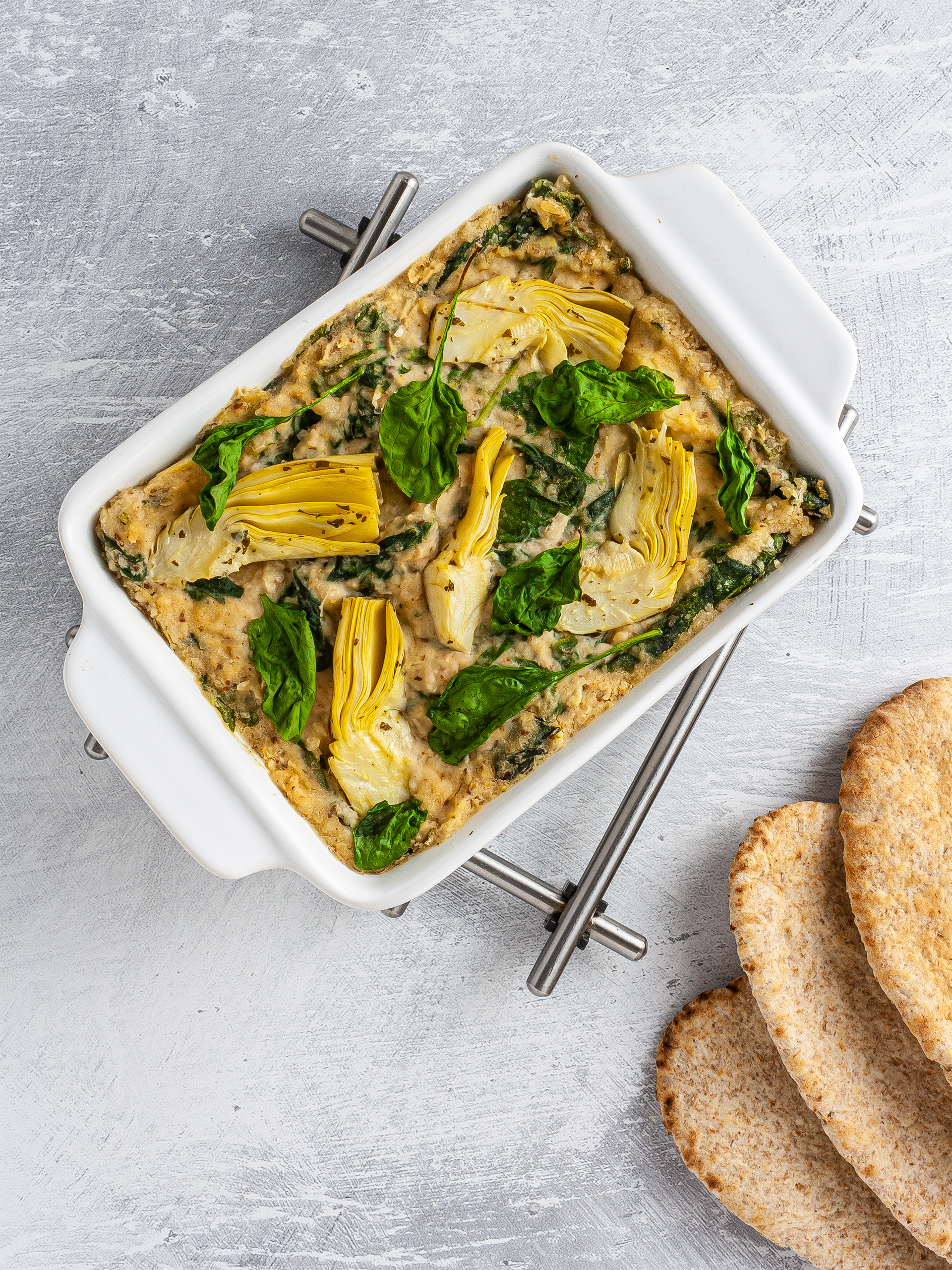 Baked spinach artichoke dip served with pitta bread.