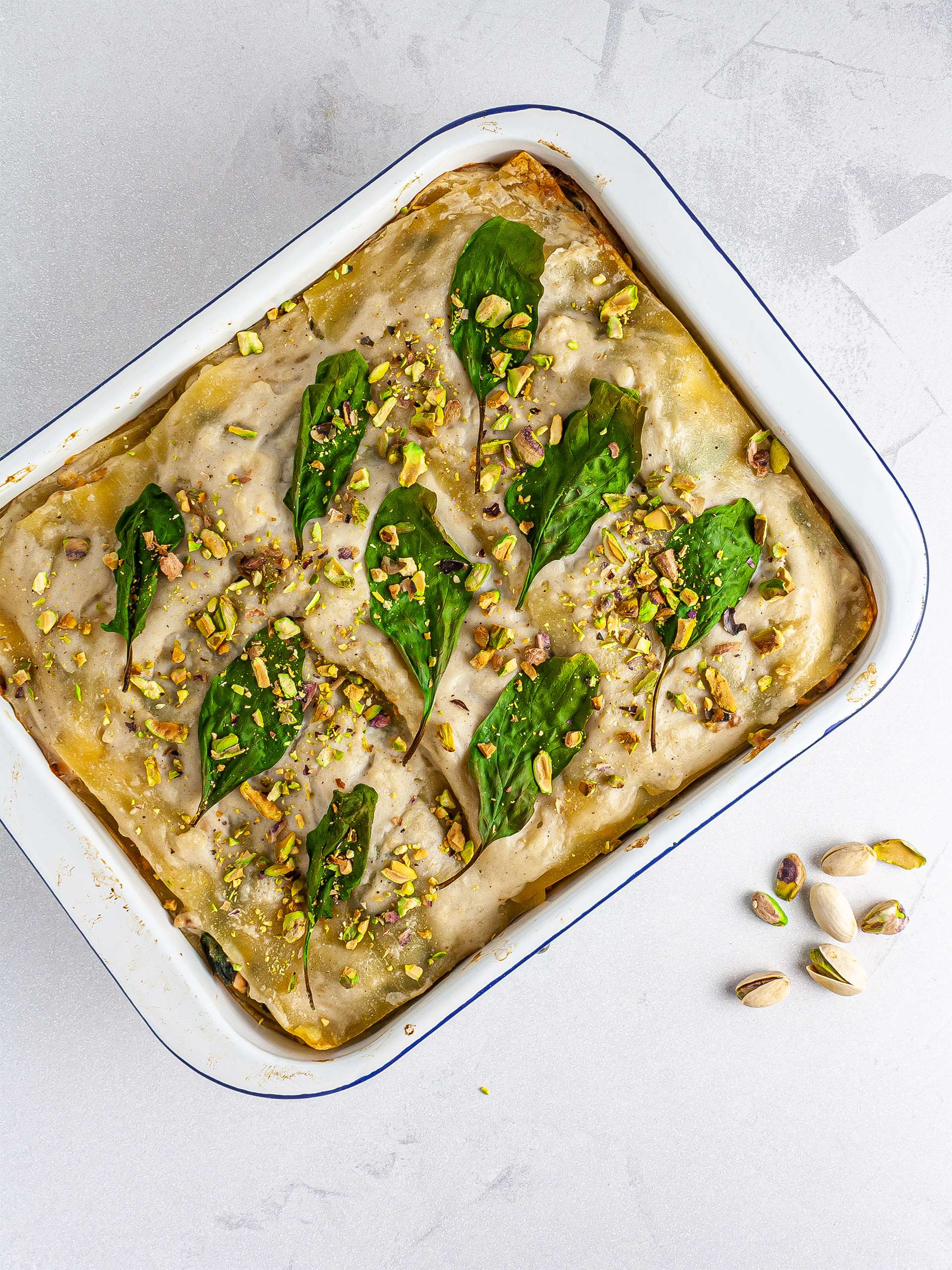 Baked spinach salmon lasagna topped with pistachio nuts