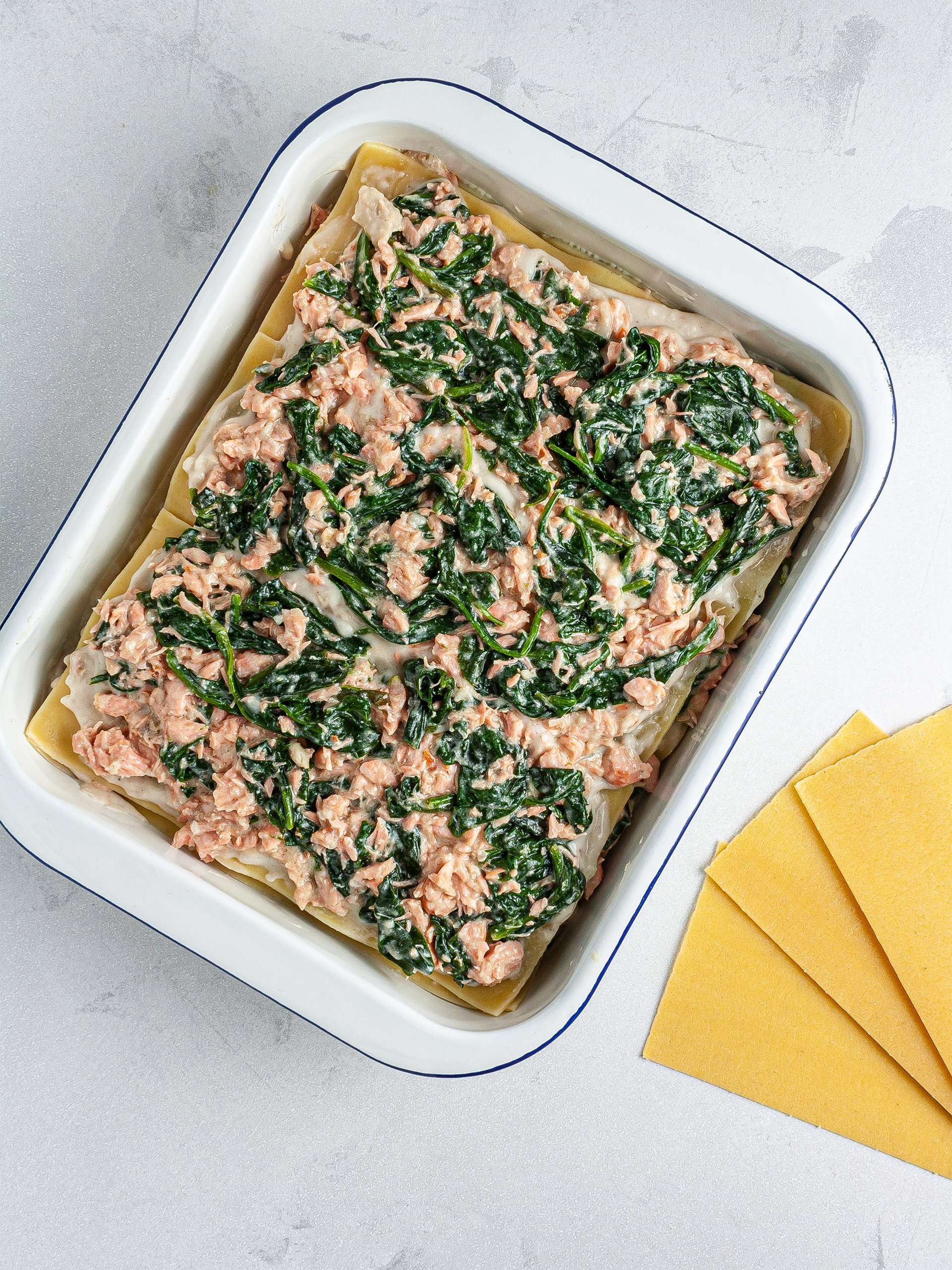 Lasagna assembled with salmon, spinach, and bechamel sauce