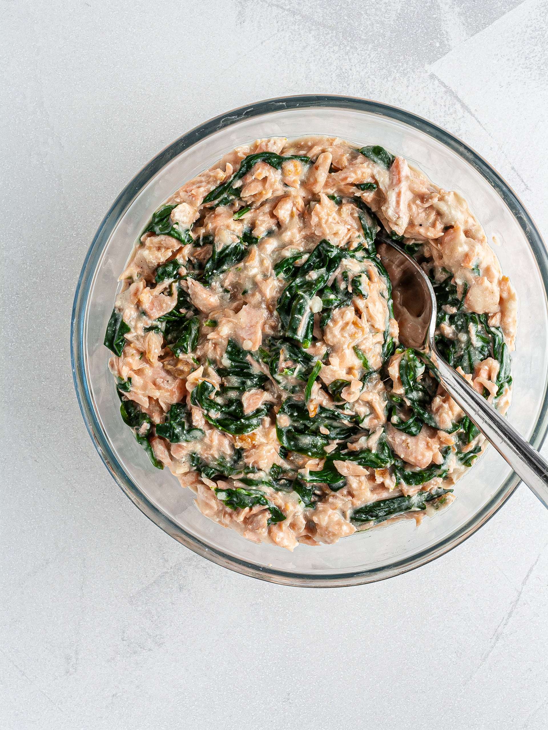 Salmon, spinach, and bechamel sauce mixed in a bowl