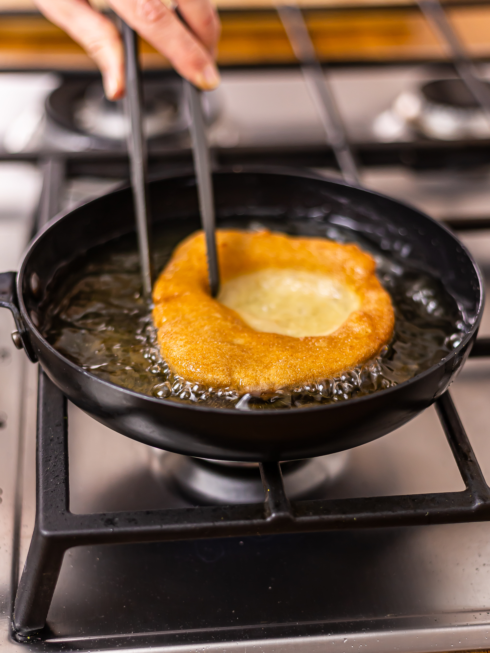 woman frying sourdough fry bread in a skillet