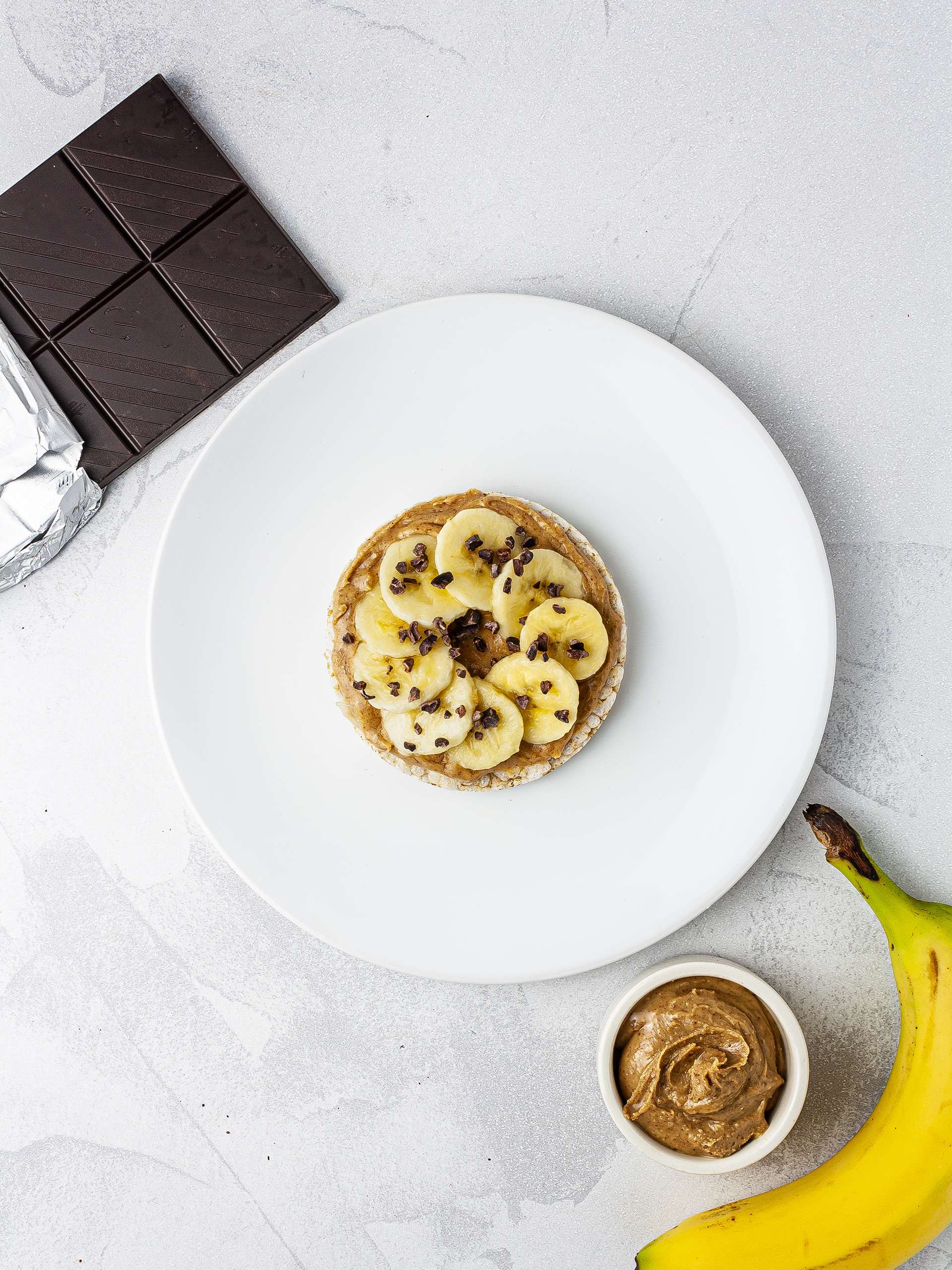 Rice cake with almond butter, sliced banana and chocolate chips.