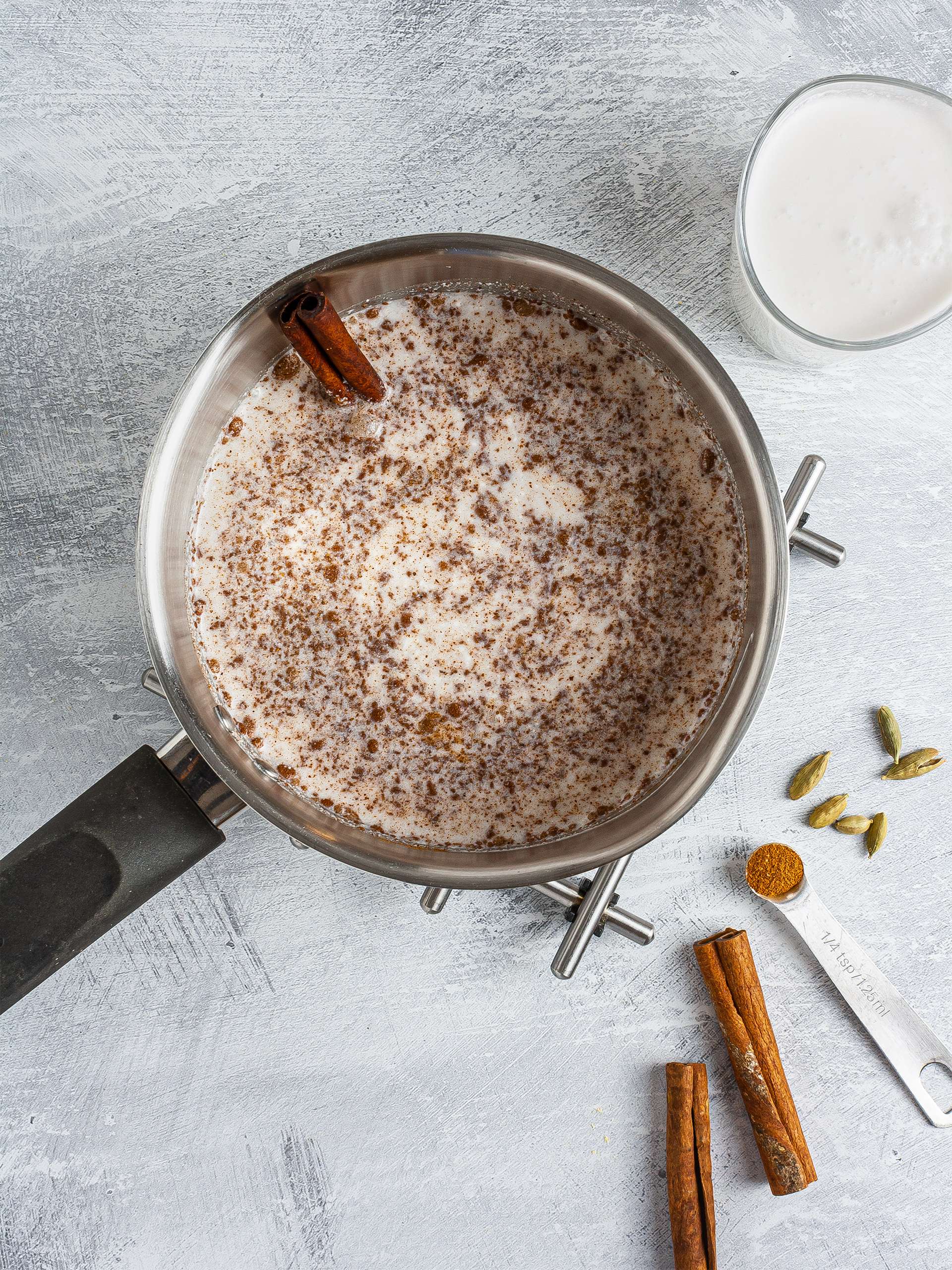Coconut milk simmering with cinnamon and cardamom
