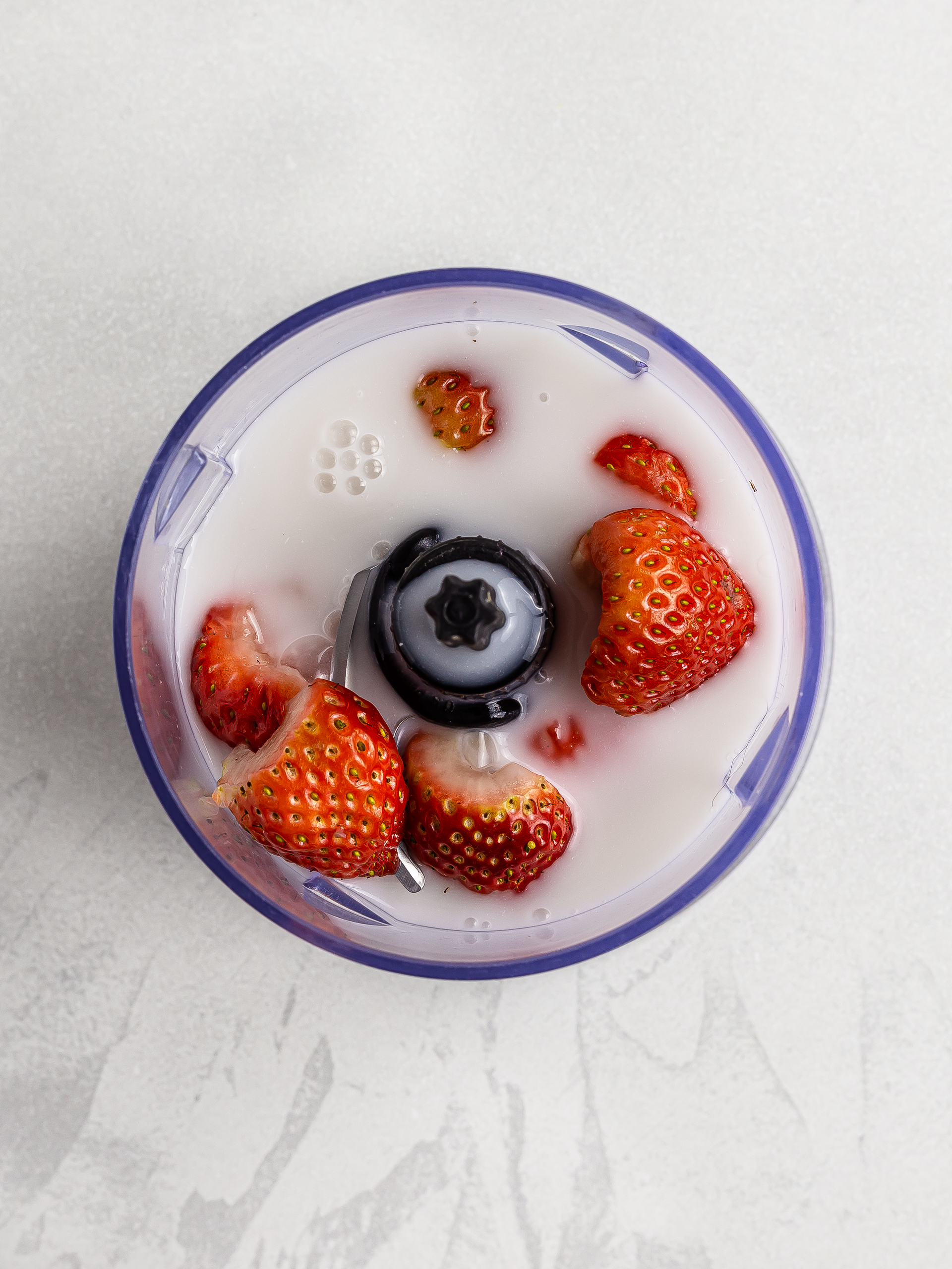 strawberries and coconut milk in a blender