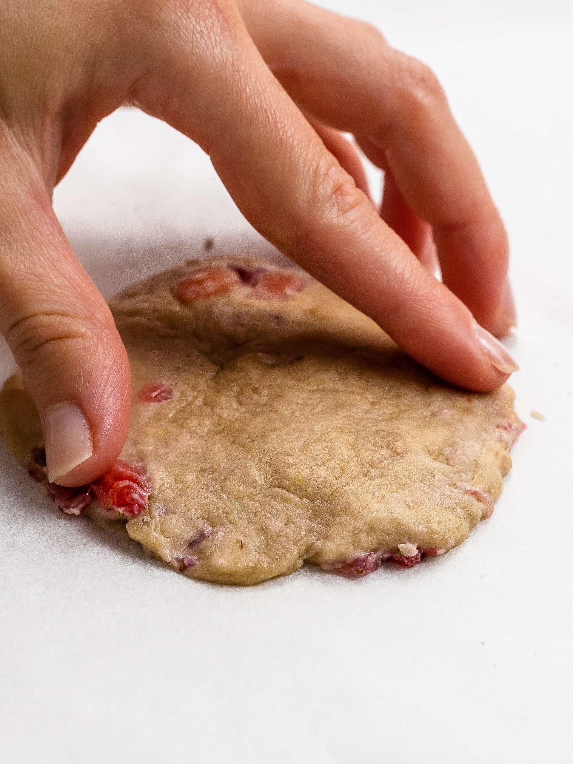 hand flattening a cookie