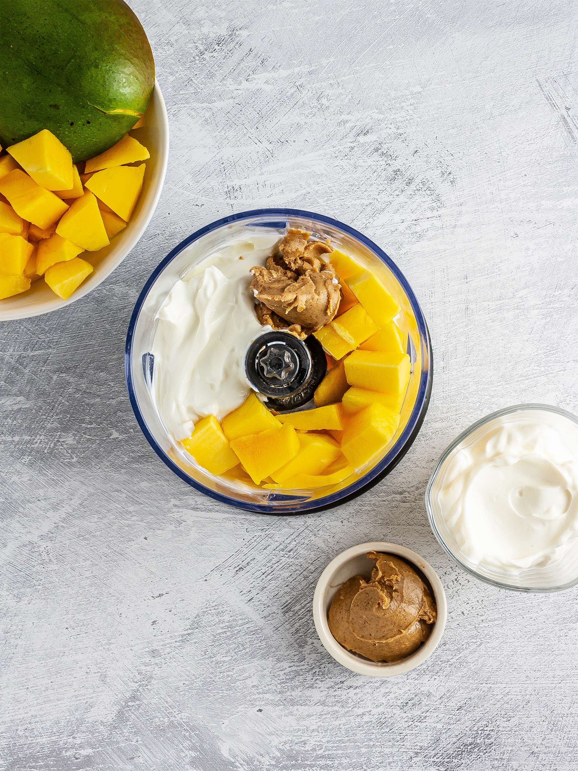 Mango chunks, yogurt, almond butter in food processor.