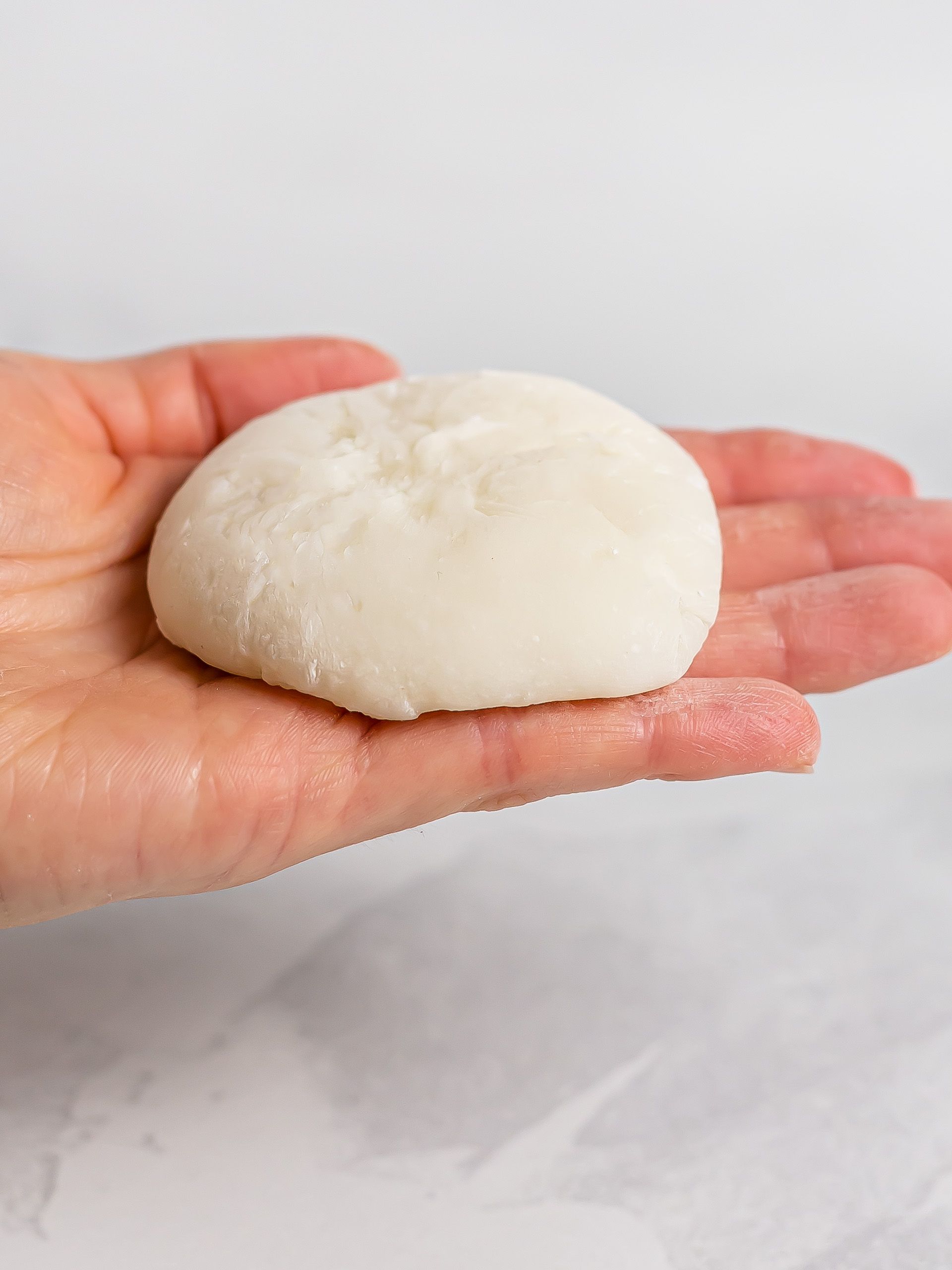 hand holding a mochi dough wrapper