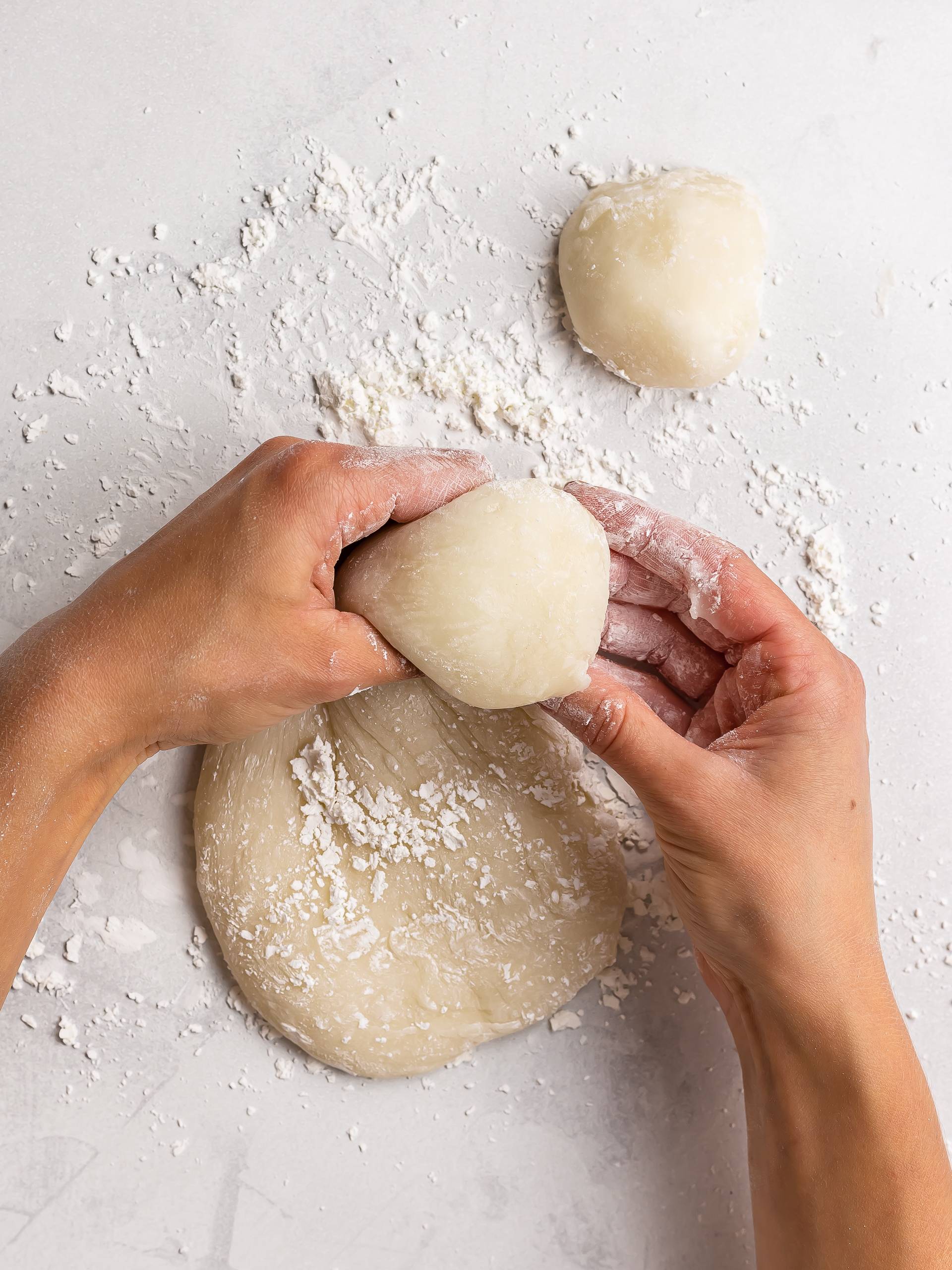 woman pinching off balls of mochi dough