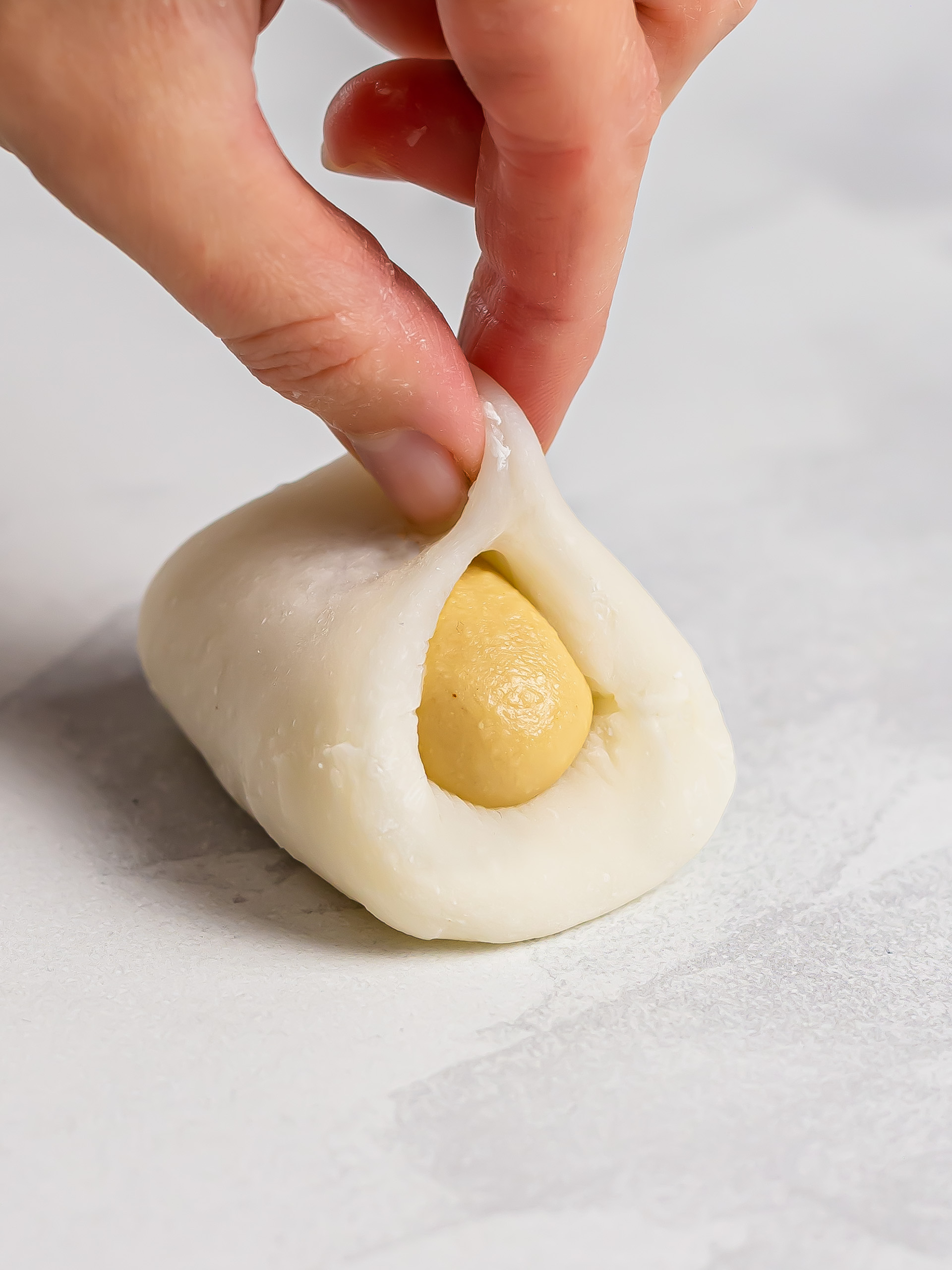 sealing mochi wrapper around peanut butter filling