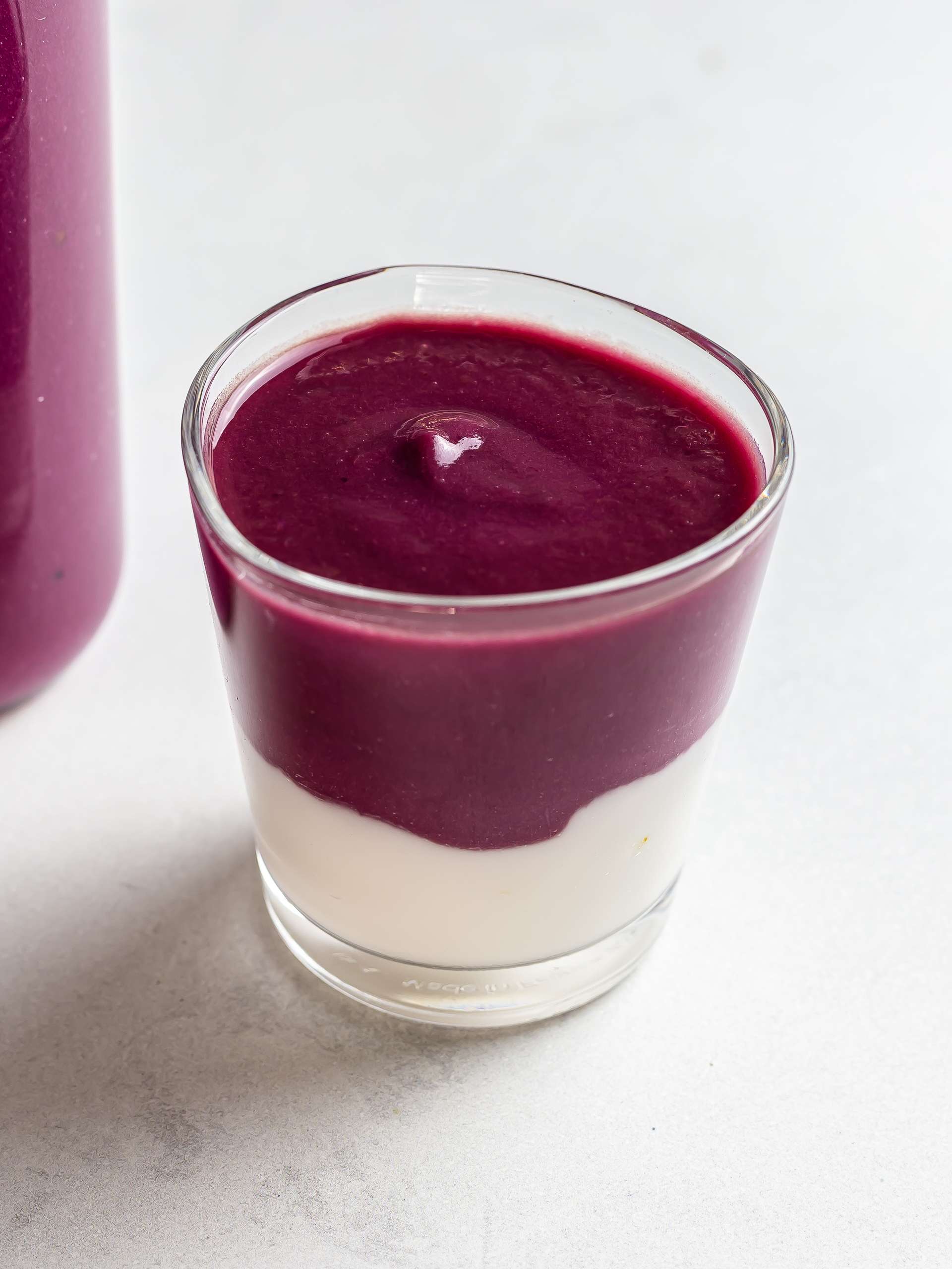 purple yam smoothie layered with yogurt in a glass