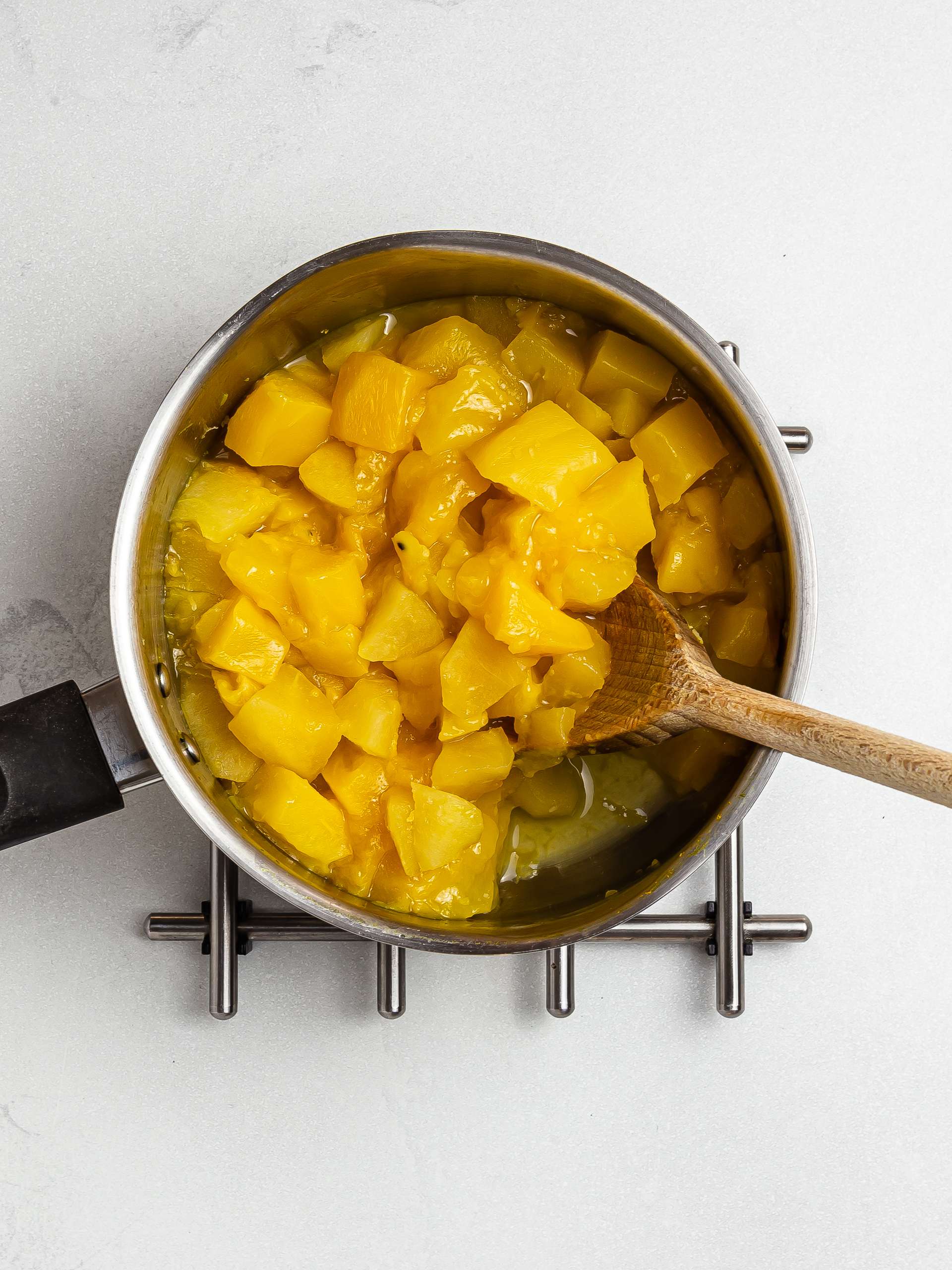 cooked mango in a pot for jam