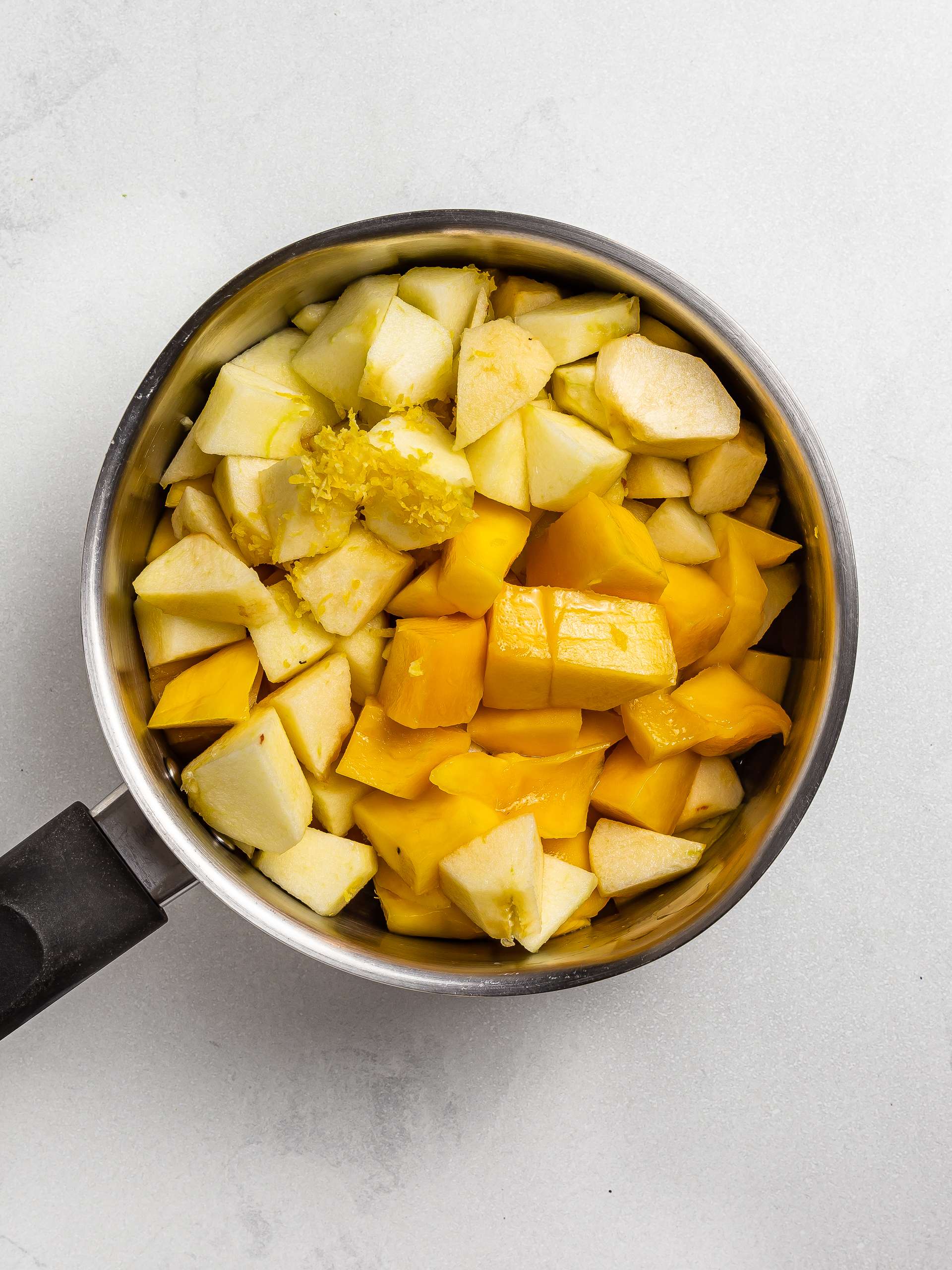 mango and apple chunks in a pot for jam