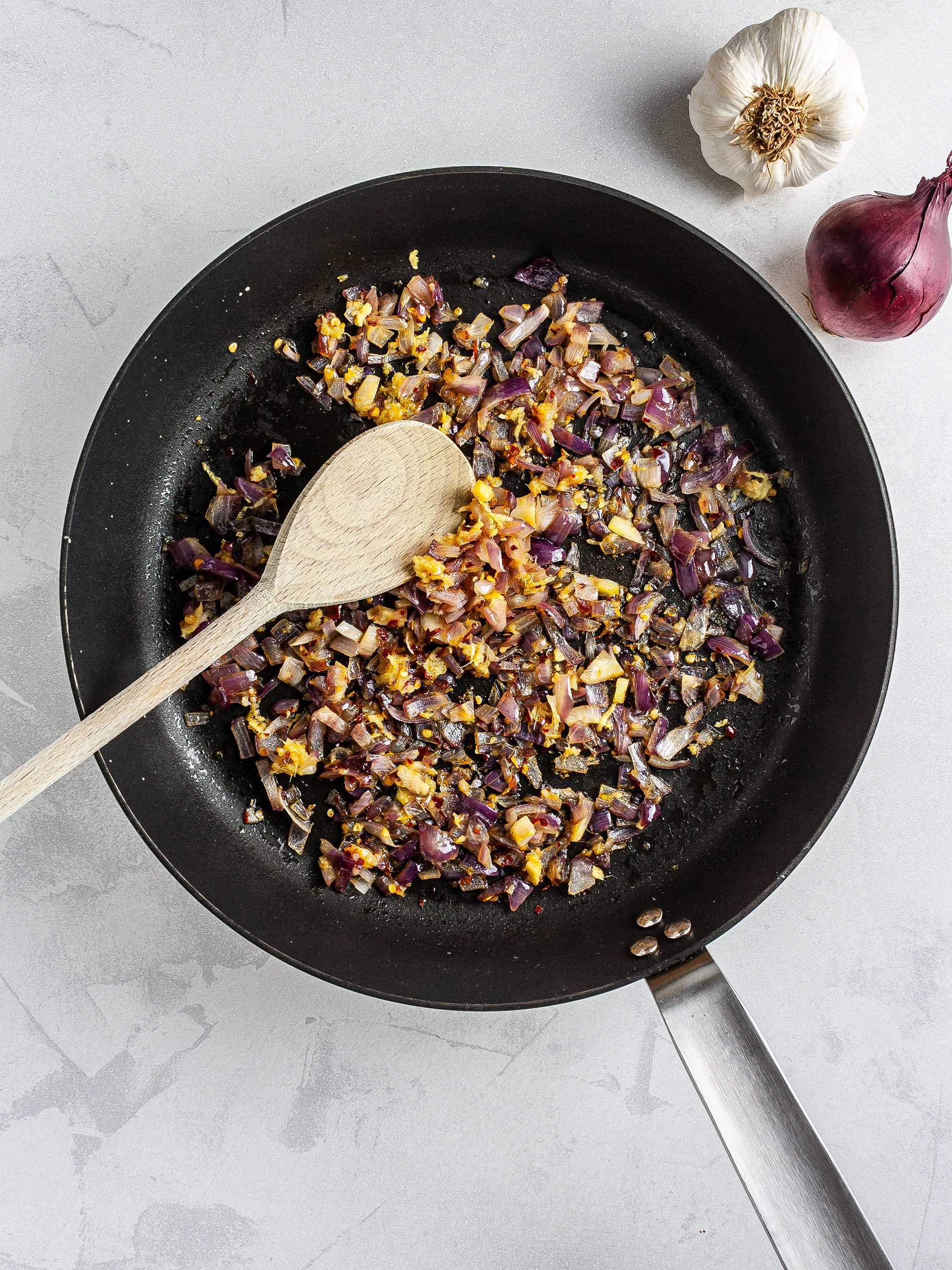 Sizzled onions, garlic, ginger, and chillies in a skillet