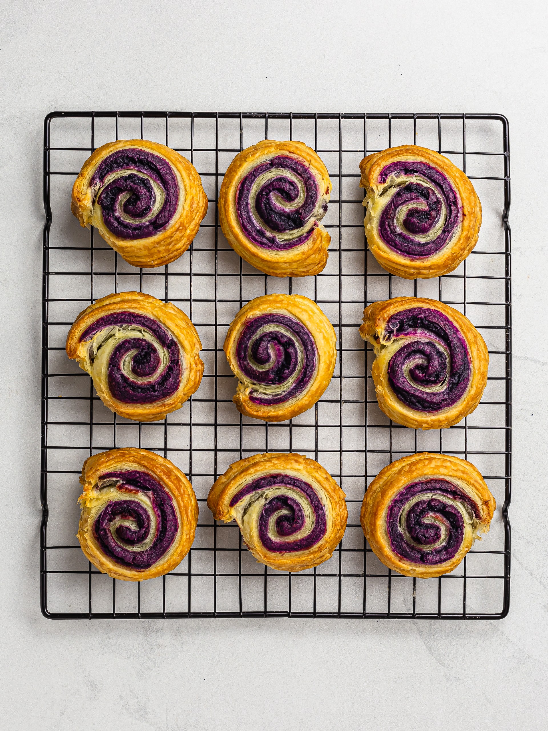 baked ube cinnamon pastry rolls on a tray