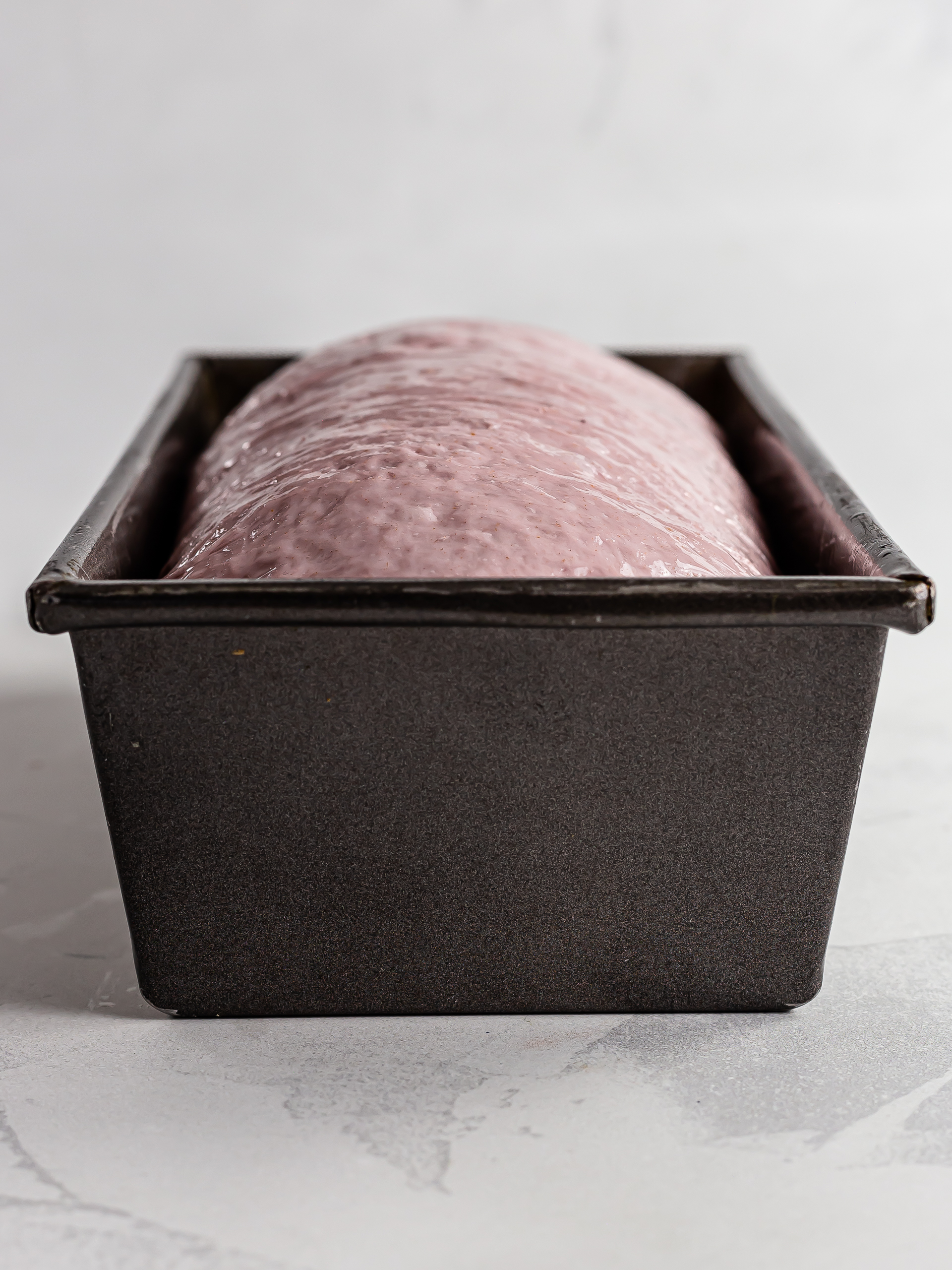 ube bread loaf proving in a tin