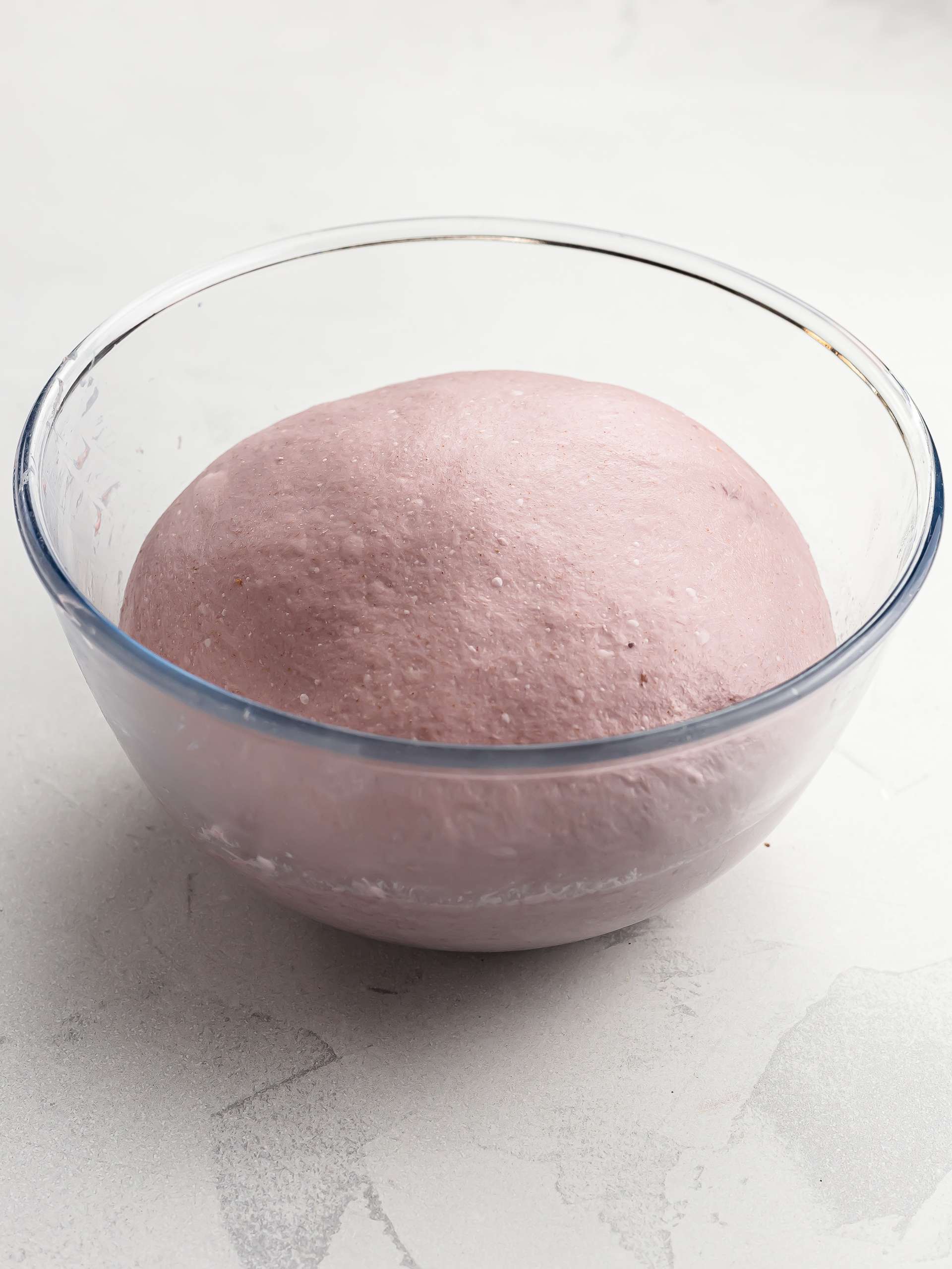 ube bread dough proving in a bowl