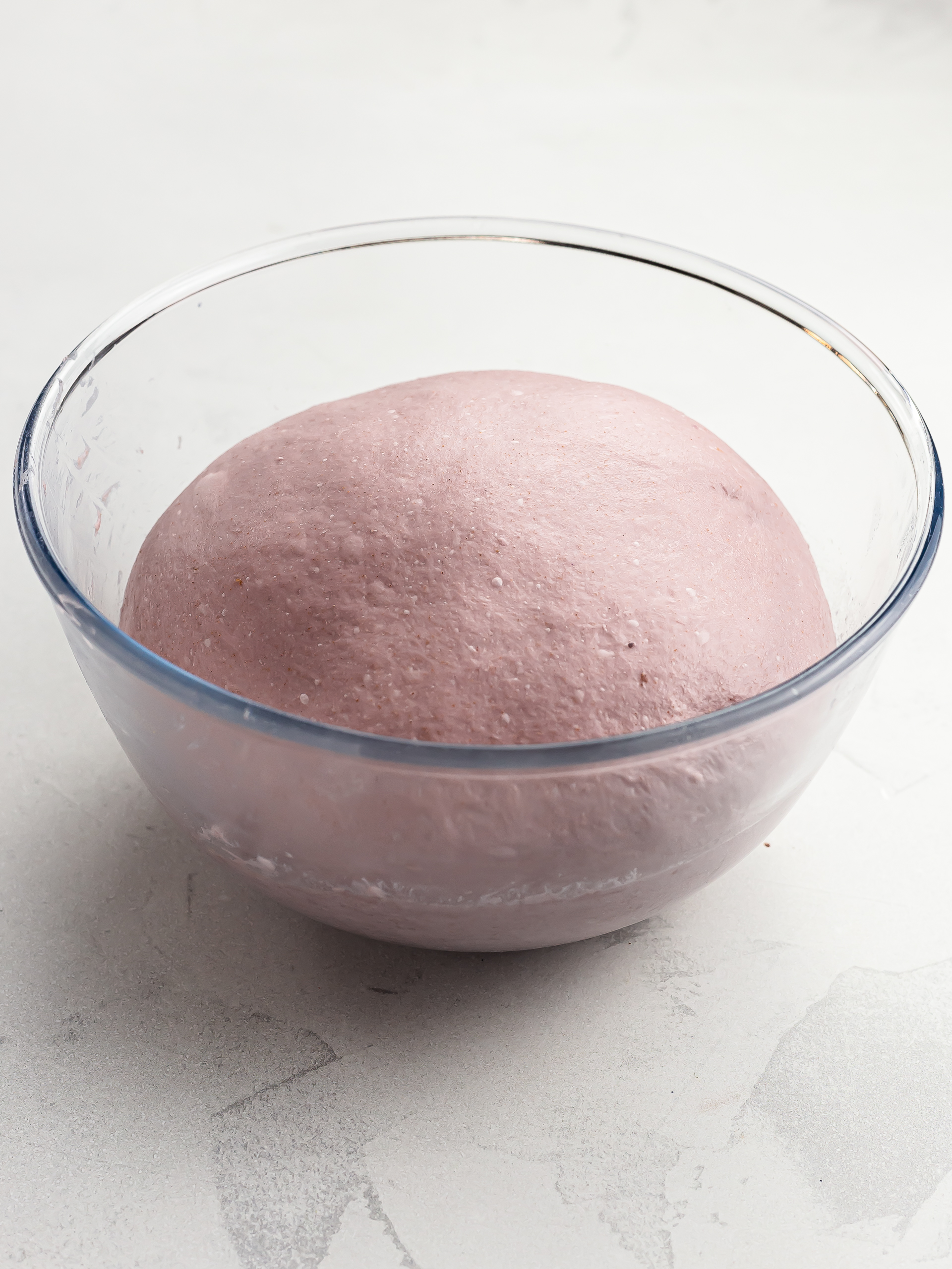 ube bread dough proving in a bowl