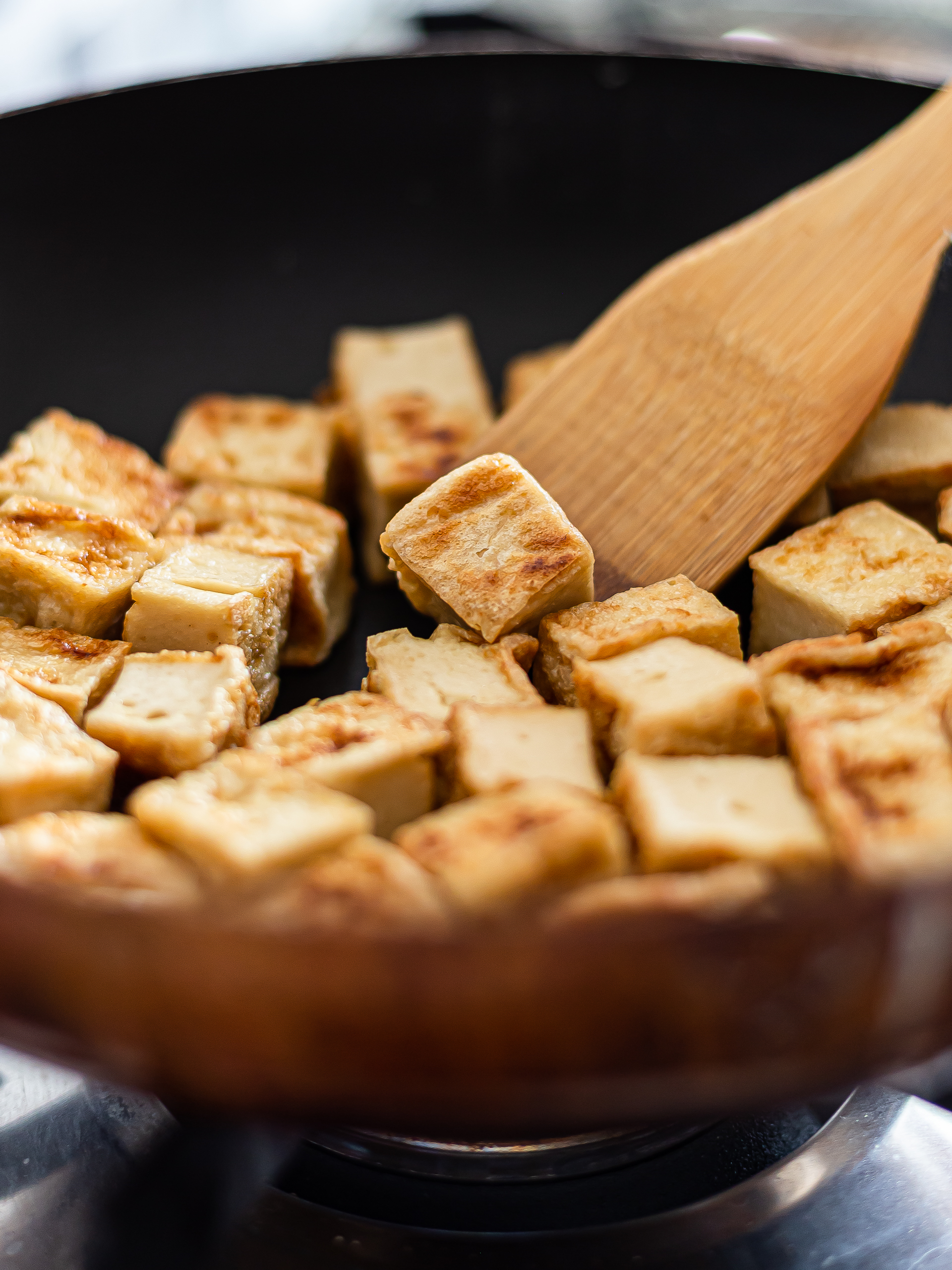 tofu cubes seared in a skillet for stir-fry