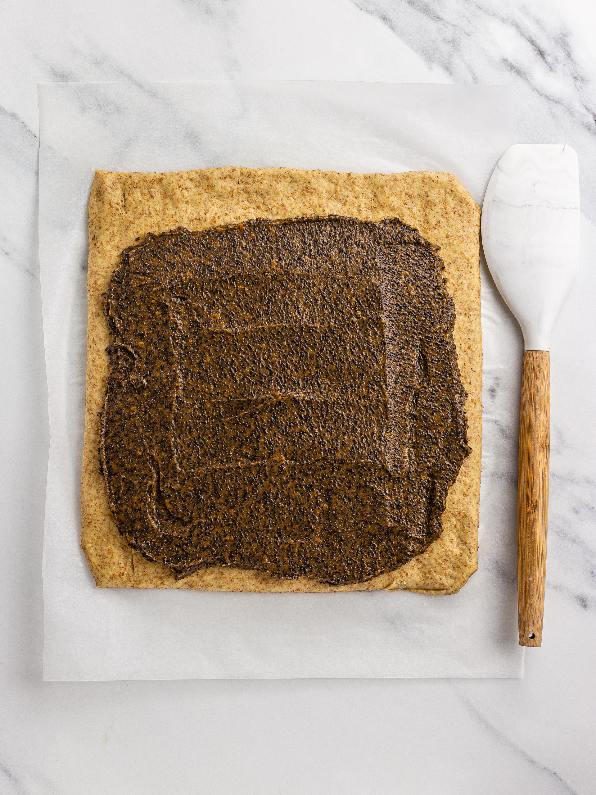 poppy seed filling spread onto cake dough