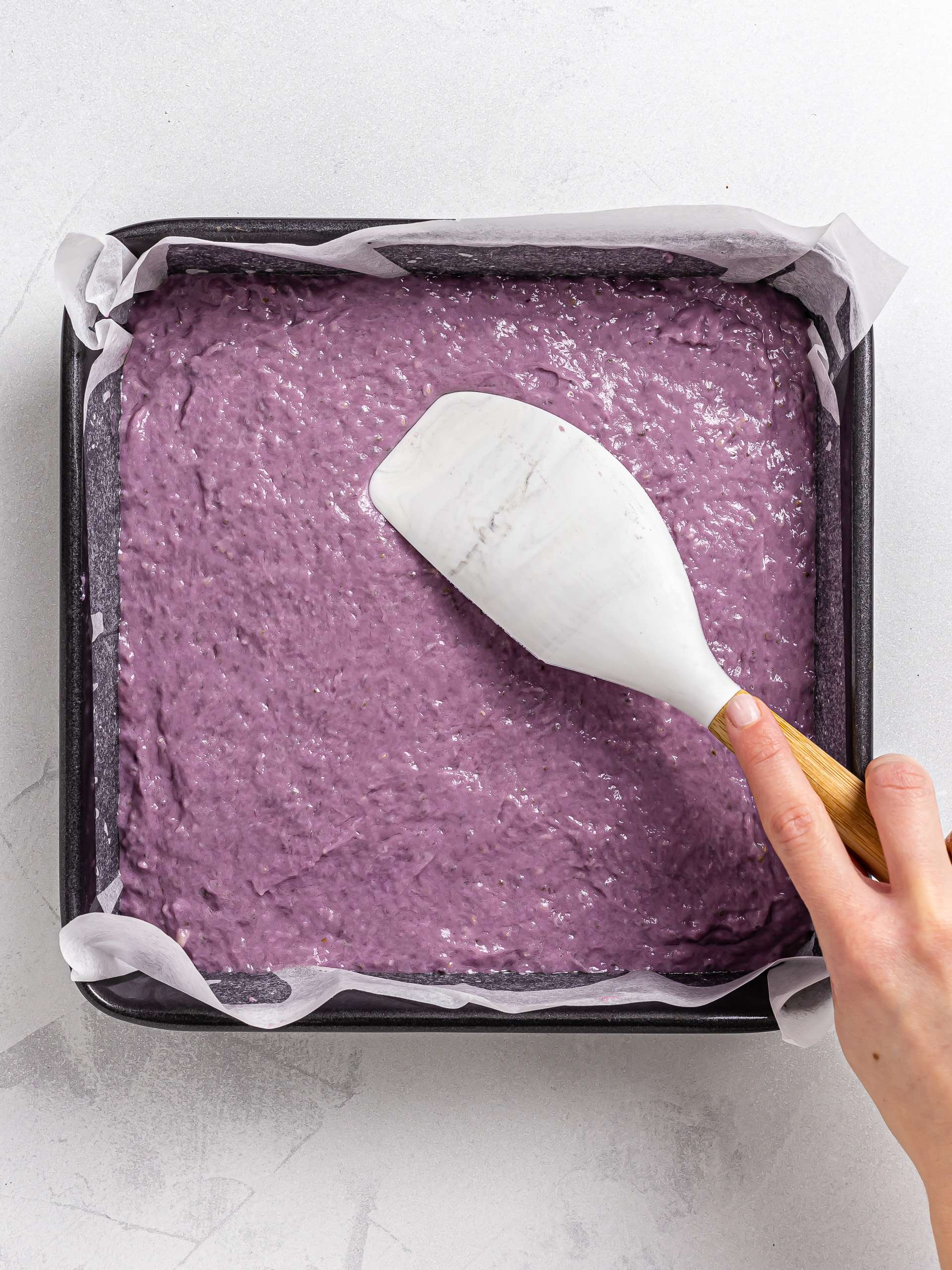 ube brownie dough into a square baking tin