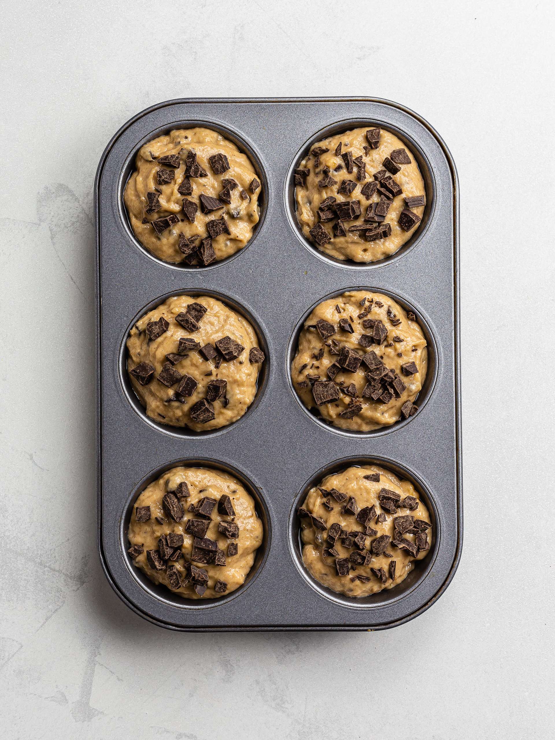plantain muffins in a tin with chocolate chips