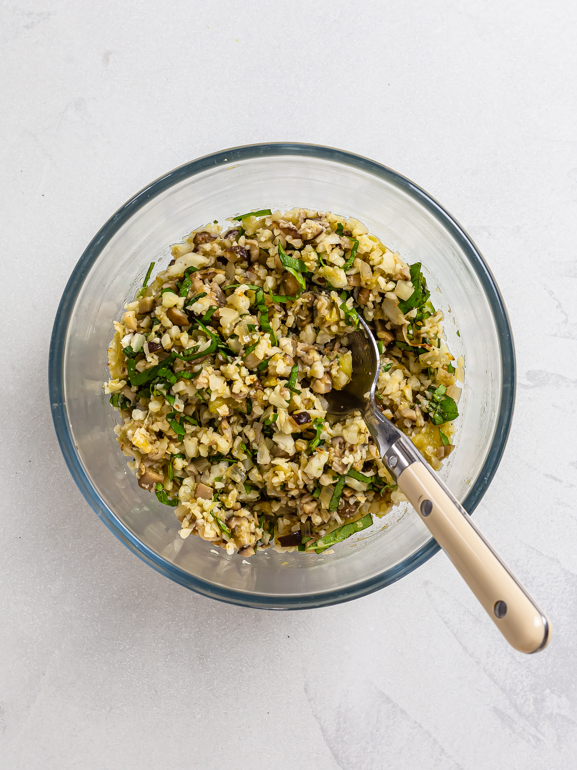 cauliflower rice mixed with mushrooms and basil in a bowl