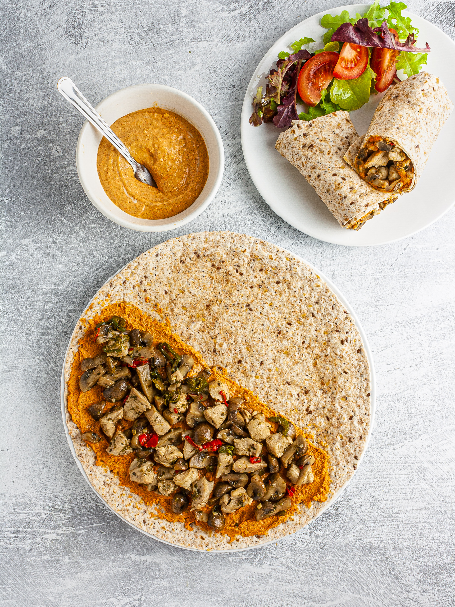 Wrap with paprika hummus, mushroom, and chicken served with a side salad