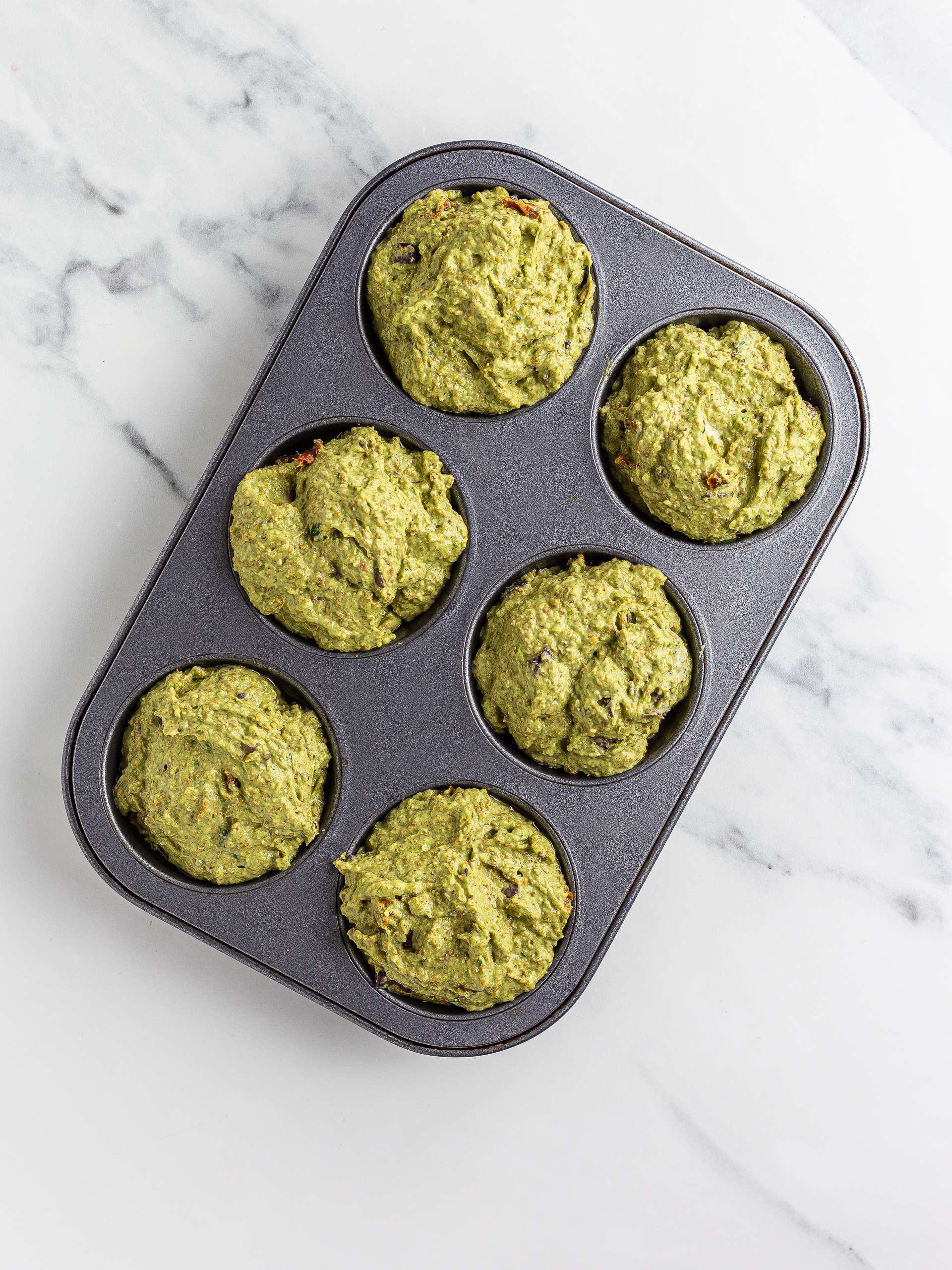 savoury vegan muffins with pesto in a muffin tin